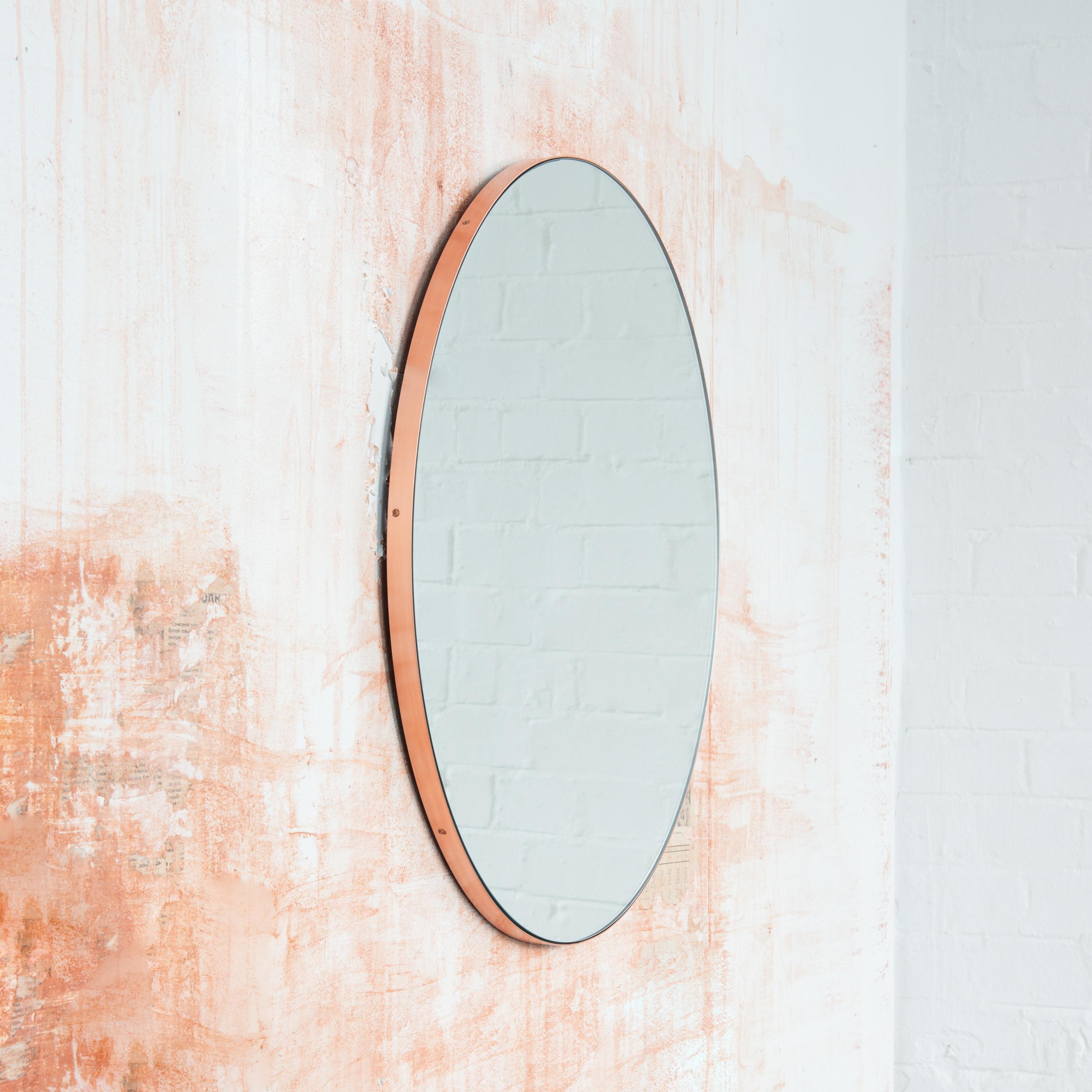 Minimalistischer runder Spiegel mit einem eleganten Rahmen aus gebürstetem Kupfer. Die Details und die Verarbeitung, einschließlich der sichtbaren verkupferten Schrauben, unterstreichen die handwerkliche Qualität des Spiegels, ein echtes