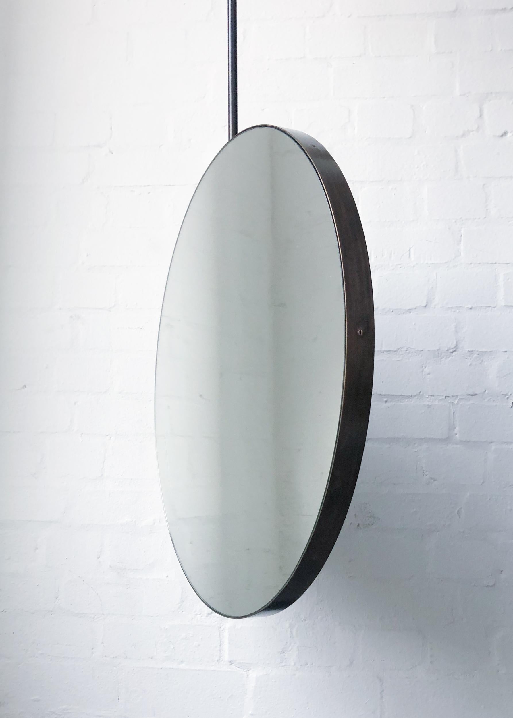 Einzigartiger und exquisiter, runder, an der Decke aufgehängter Spiegel mit einem Rahmen aus Messing, der mit einer eleganten Bronzepatina versehen ist.

550mm (21.65