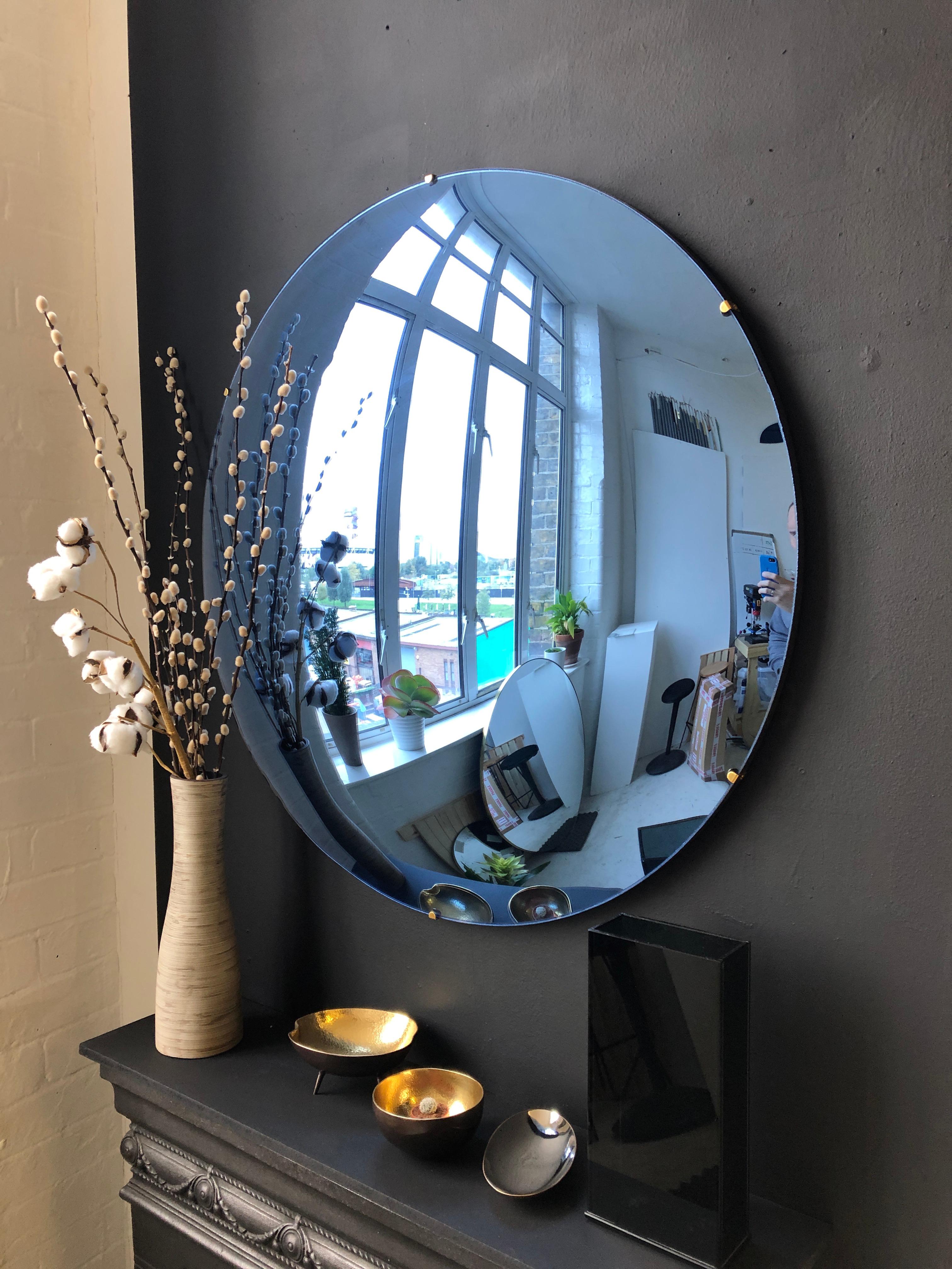 Stunning frameless blue convex mirror for a unique statement above a fireplace, a console table or anywhere in a home, hospitality or commercial space.

Each Orbis convex mirror is handcrafted. Slight variations in dimensions, tint and finish are