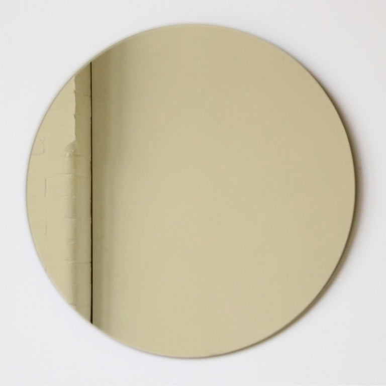 Charming and minimalist gold tinted round frameless mirror with a floating effect.

Quality design that ensures the mirror sits perfectly parallel to the wall. Designed and made in London, UK.

Fitted with professional plates not visible once