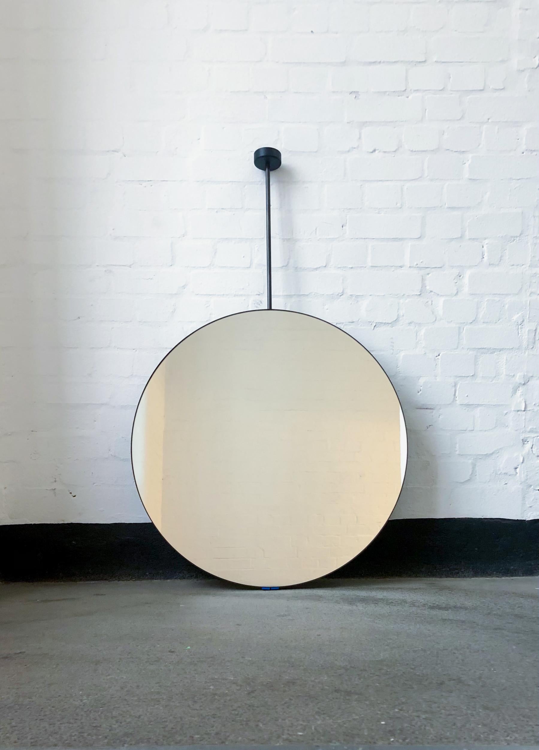 Charmant miroir rond suspendu au plafond avec un cadre en acier inoxydable noirci.

650 mm (25,6