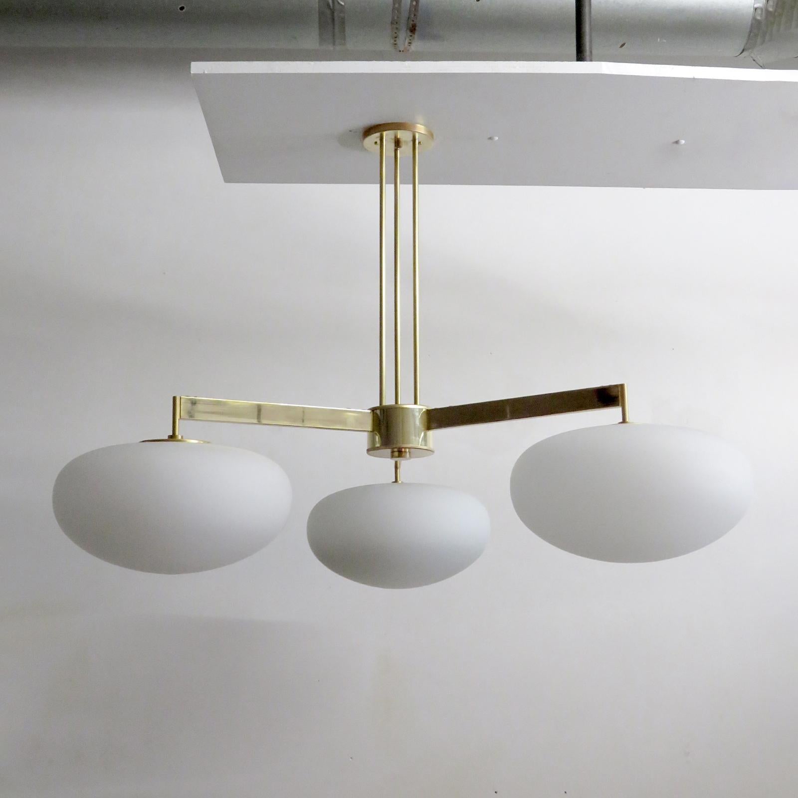 stunning large-scale three-arm flush mount fixture by Gallery L7, handcrafted and finished in Los Angeles from American brass with polished brass finish and three matte opaline glass globes, measures 40 x 30 inch, three E26 sockets per fixture, max.