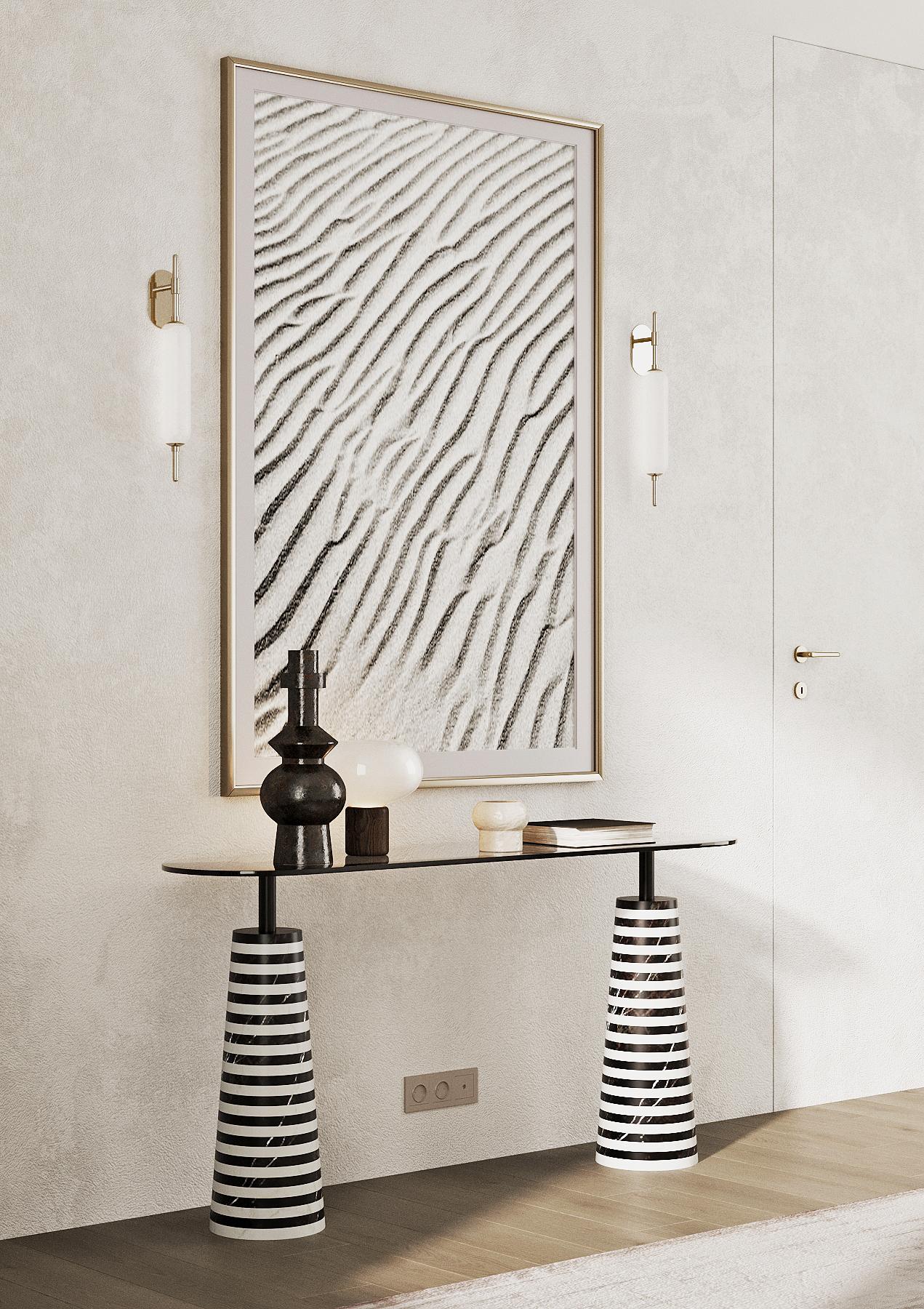 A futuristic console table showcases a black securit oval glass top based on a symmetrical striped black and white marble solid base. Crafted with a beautifully contemporary shape, can complement an array of interior design styles. Expertly