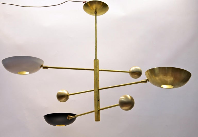 This superb bespoke brass chandelier features three rotating arms skillfully balanced on a heavy cast brass sphere that rotate in an orbital movement along the stem. To achieve perfect balance, each sphere is filled with sand, creating a point of no