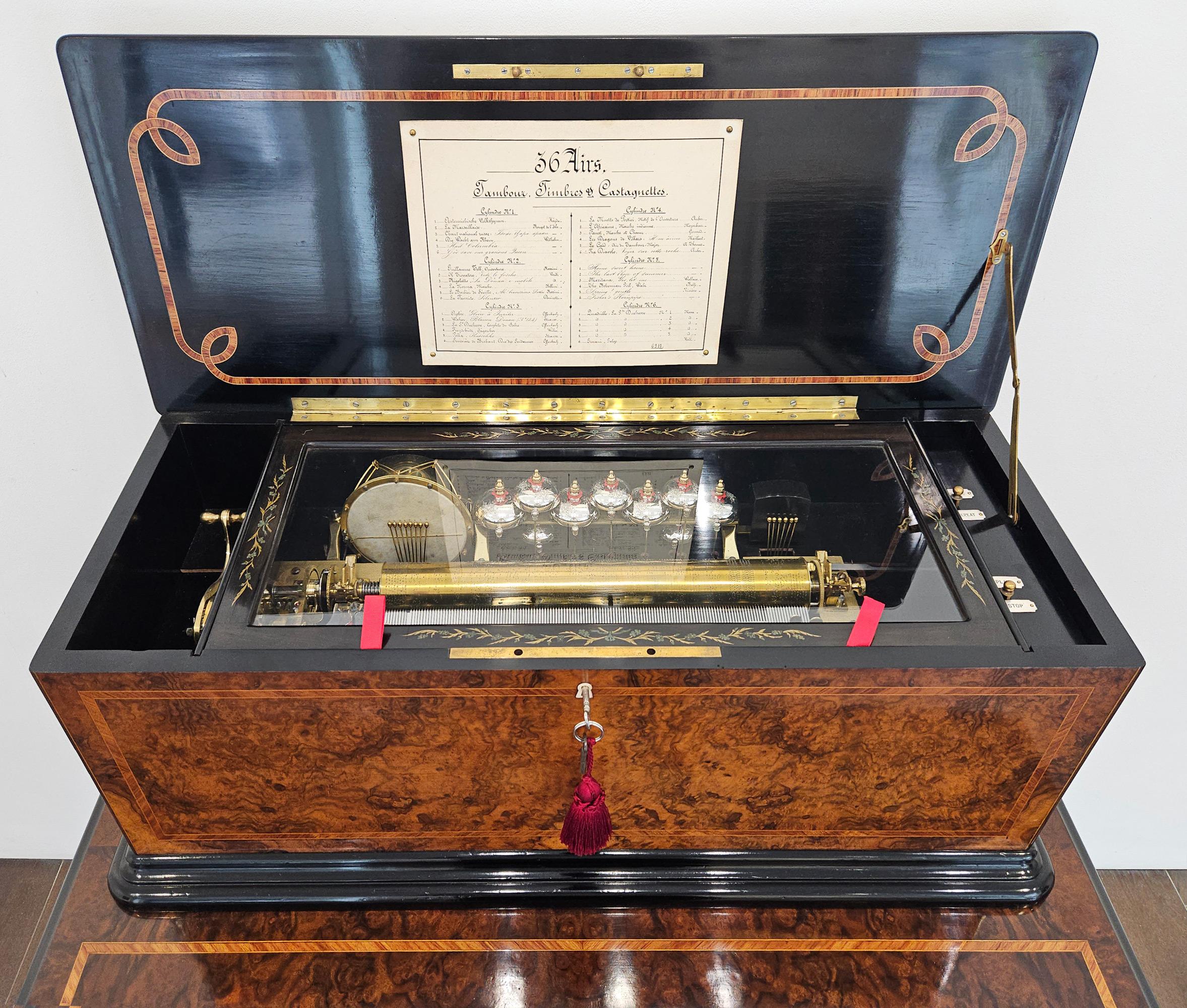A magnificent drum, bell, and castanet orchestral music box with six interchangeable cylinders on matching table, made by Ducommun Girod in Geneva, Switzerland c. 1870. 

The mechanical musical movement features nine bells, each individually