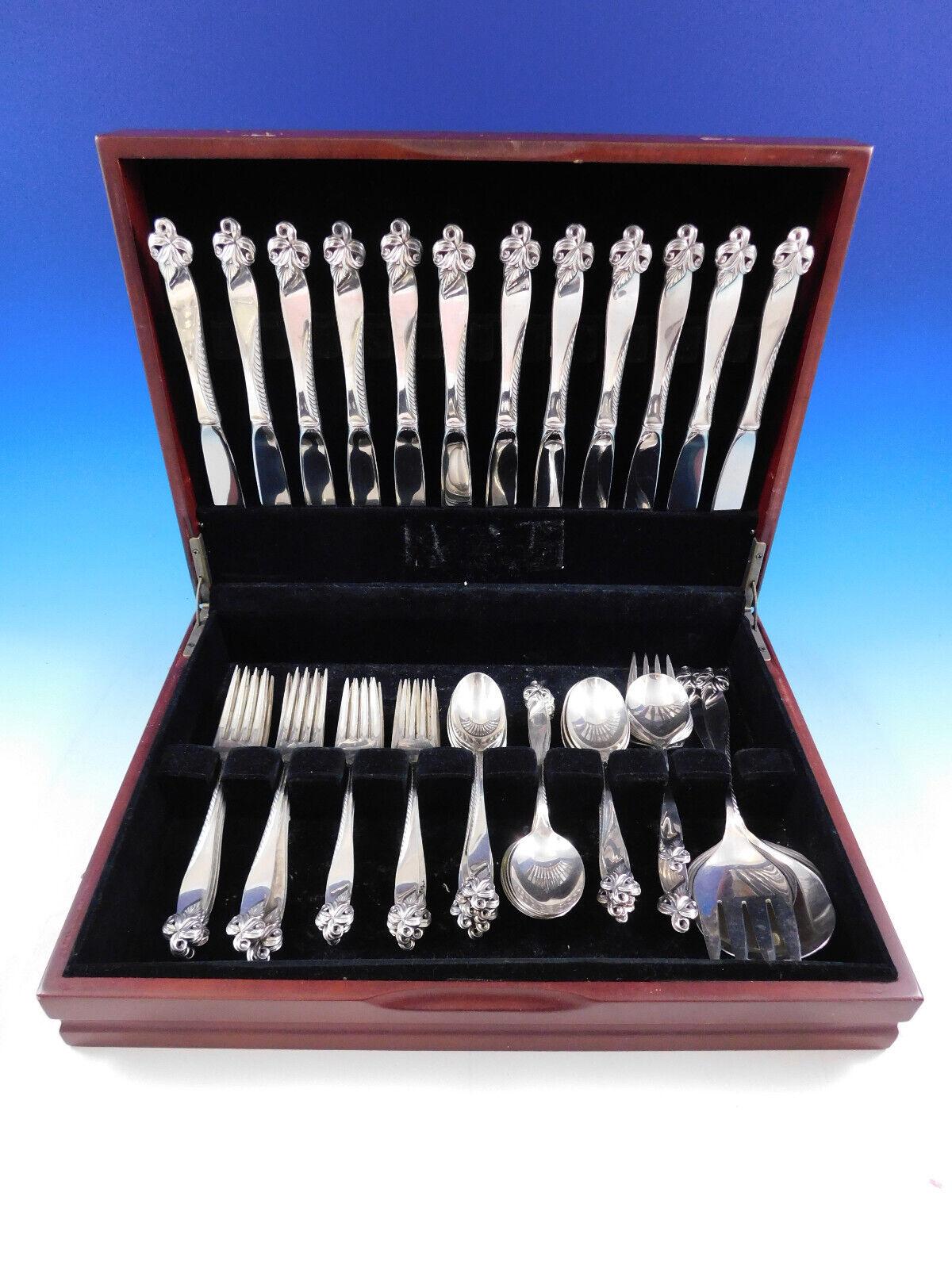 Orchid Elegance by Wallace Sterling Silver flatware set with unique pierced, floral shaped handle - 64 pieces. This set includes:

12 Knives, 9