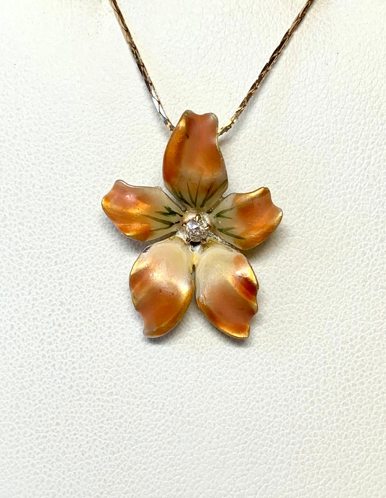 il s'agit d'un pendentif lavallière de style victorien - art nouveau en forme de fleur ou d'orchidée - si étonnant avec un spectaculaire émail multicolore orange, crème et jaune de la plus haute qualité, serti d'un diamant rayonnant de grande