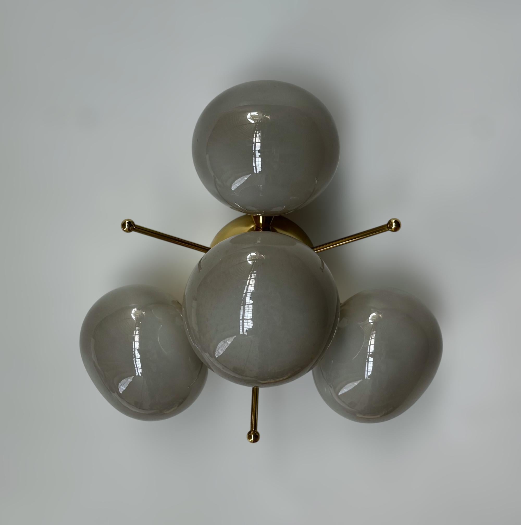 Italian flush mount with 4 pebble shaped Murano glass shades mounted on solid brass frame in lacquered polished brass finish
Designed by Fabio Bergomi / Made in Italy
4 lights / E12 or E14 type / max 40W each
Diameter: `20 inches / Height: 10.5