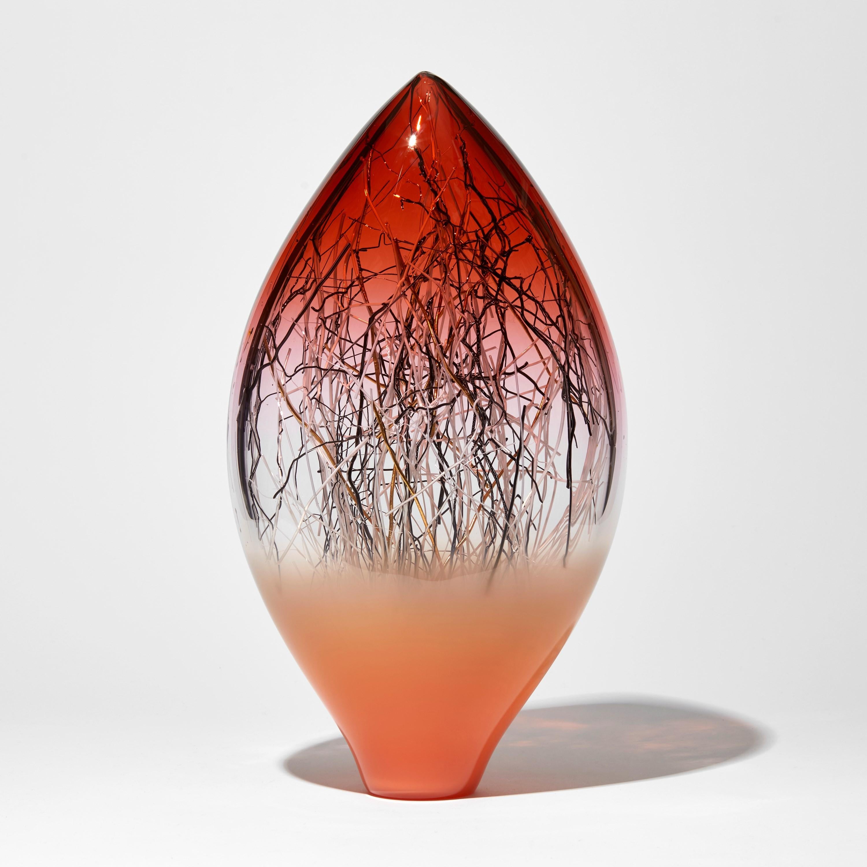 'Ore Eclipse in Salmon & Sunset Red with Gold' is a unique handblown and sculpted glass artwork by the Danish and British artists, Hanne Enemark & Louis Thompson.

Trapped inside the outer ovoid shape are a multitude of glass canes, each reaching