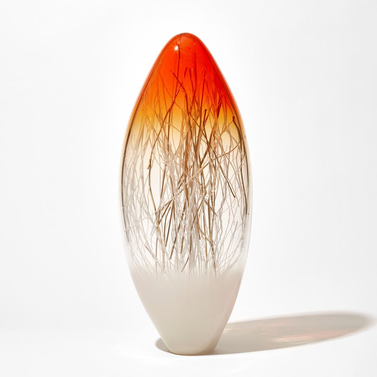 ''Ore in Bright Orange & Ecru with Gold'' is a unique glass sculpture by the collaborative artists Hanne Enemark (Danish) and Louis Thompson (British). The outer glass form contains a multitude of fine white canes of glass, some of which have been