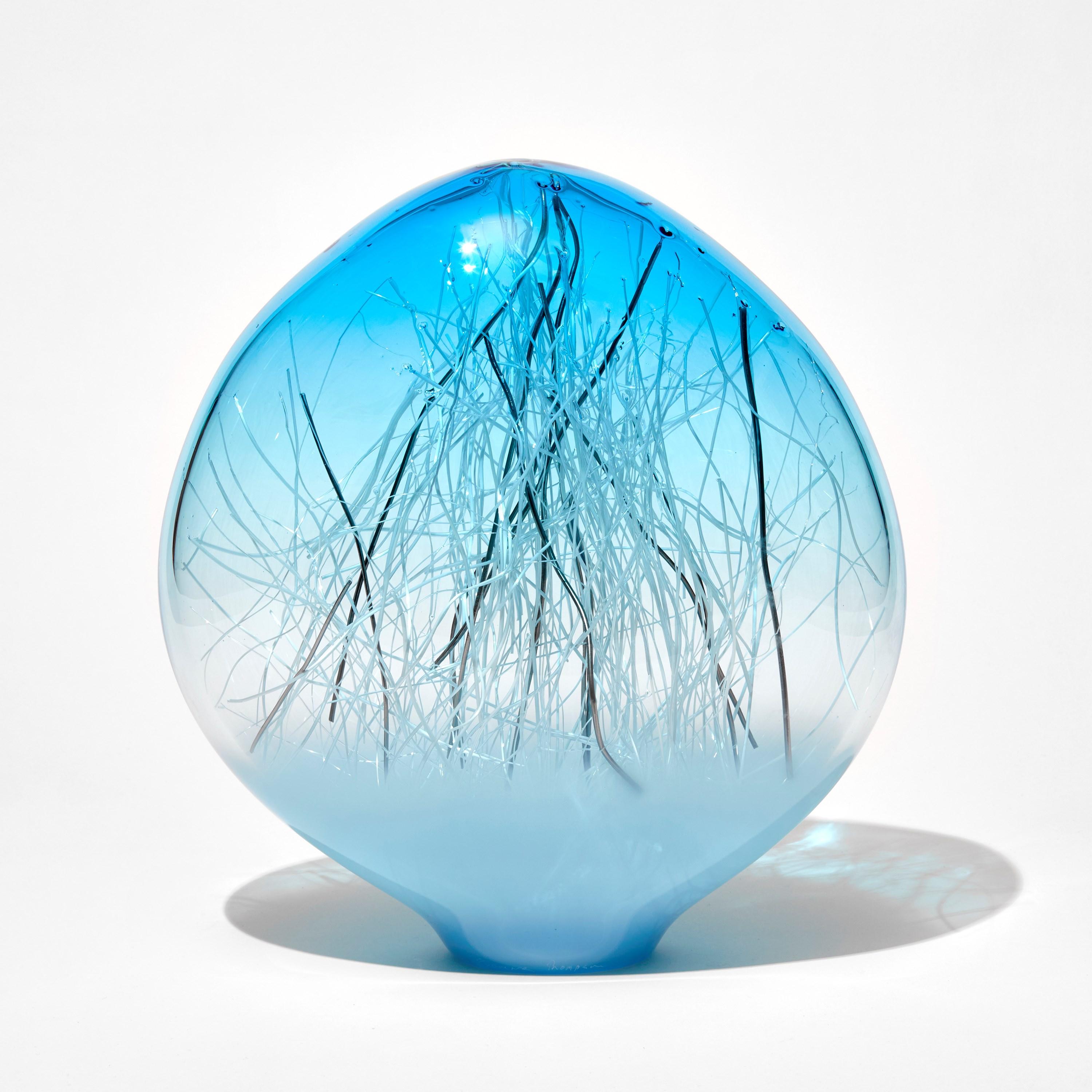 'Ore in Copper Blue & Pale Turquoise and Platinum' is a unique glass sculpture by the collaborative artists Hanne Enemark (Danish) and Louis Thompson (British). The outer glass form contains a multitude of fine white canes of glass, some of which
