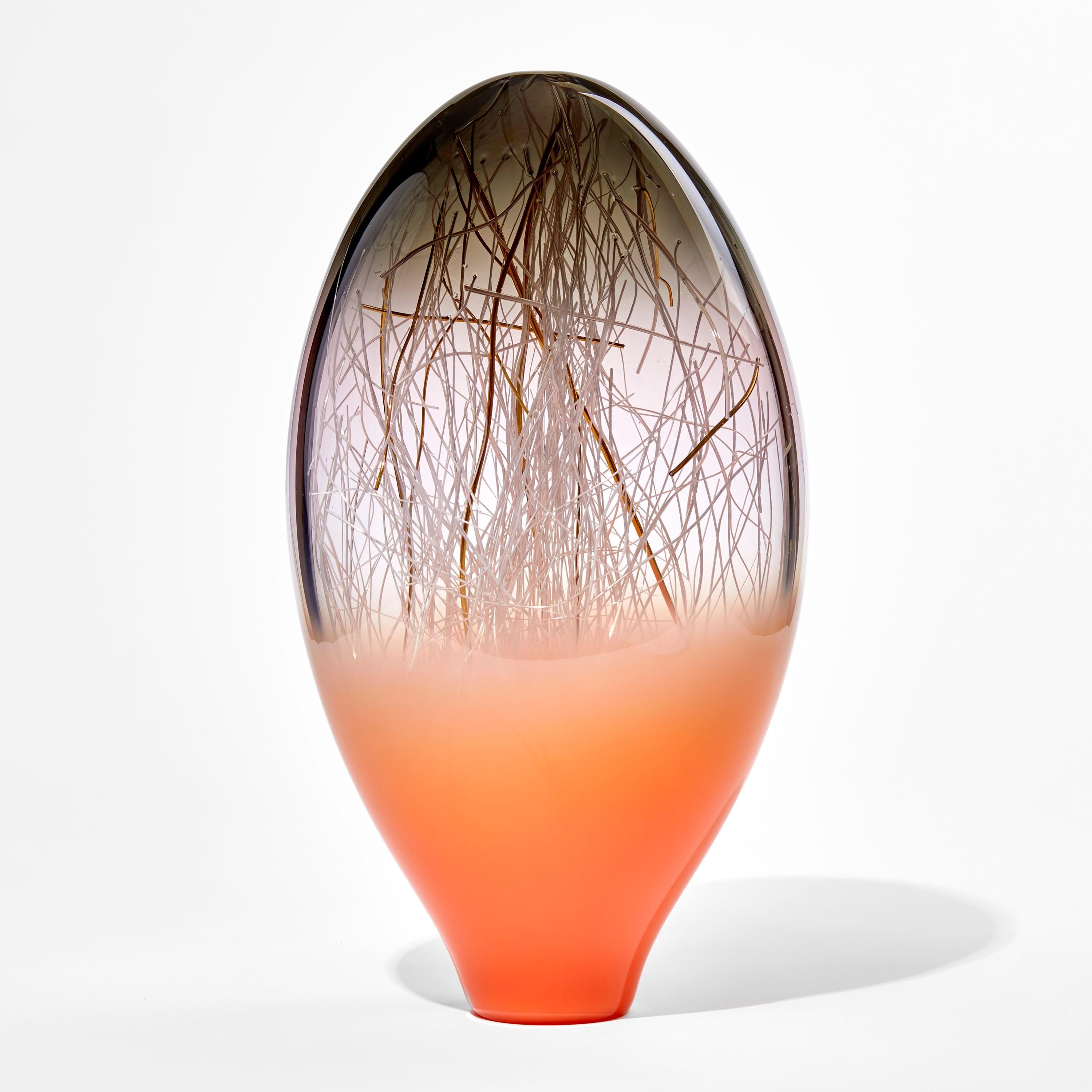 Ore in Salmon & Grey is a unique glass sculpture in coral orange, grey and clear colored glass by the collaborative artists Hanne Enemark (Danish) and Louis Thompson (British). The outer glass form contains a multitude of fine white canes of glass,