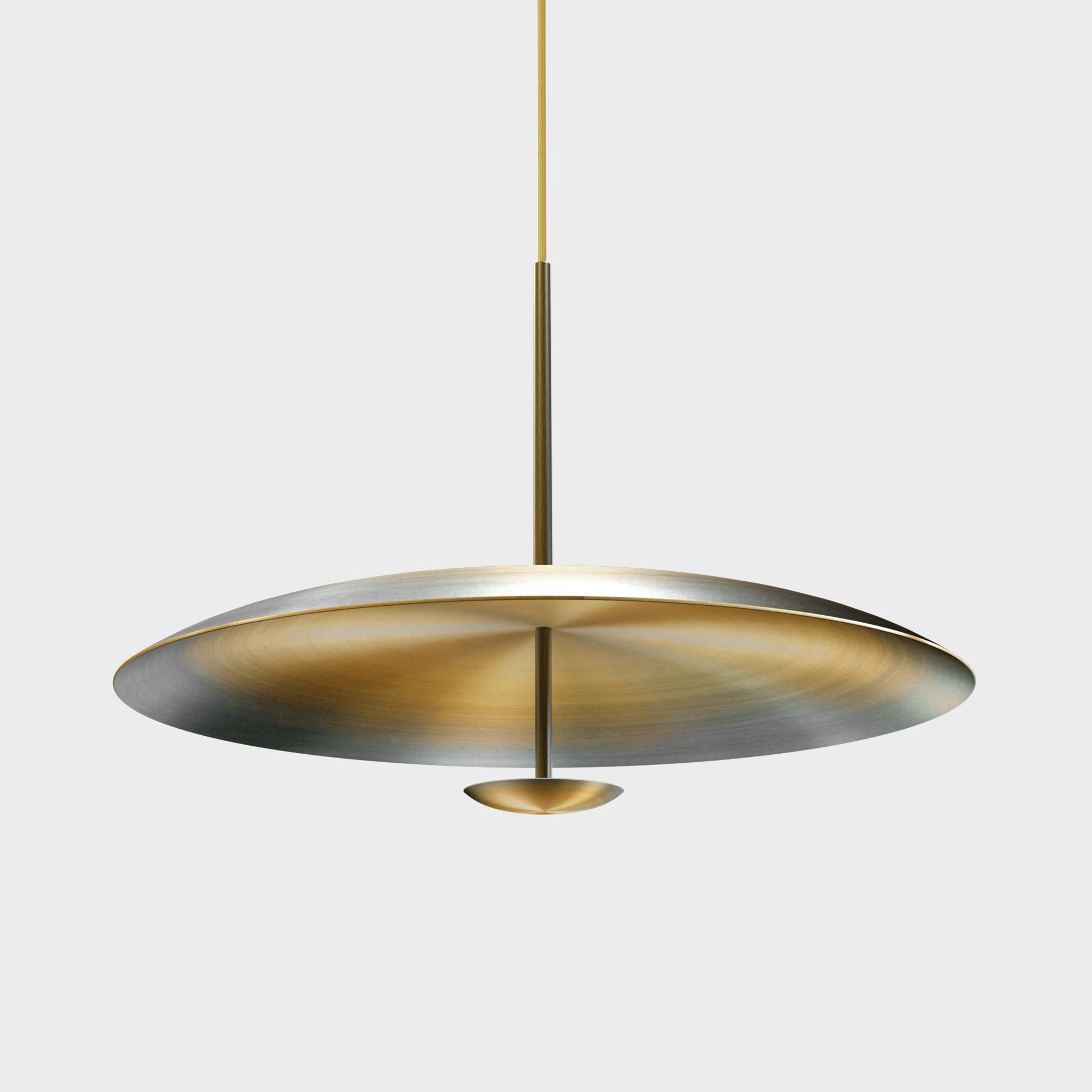Unique opportunity to procure a gorgeous pendant light designed by international illumination artist Eva Menz. Two finely hand-spun brass plates make up this pendant light, a bronze to brass gradient accentuates the shape. The light is projected