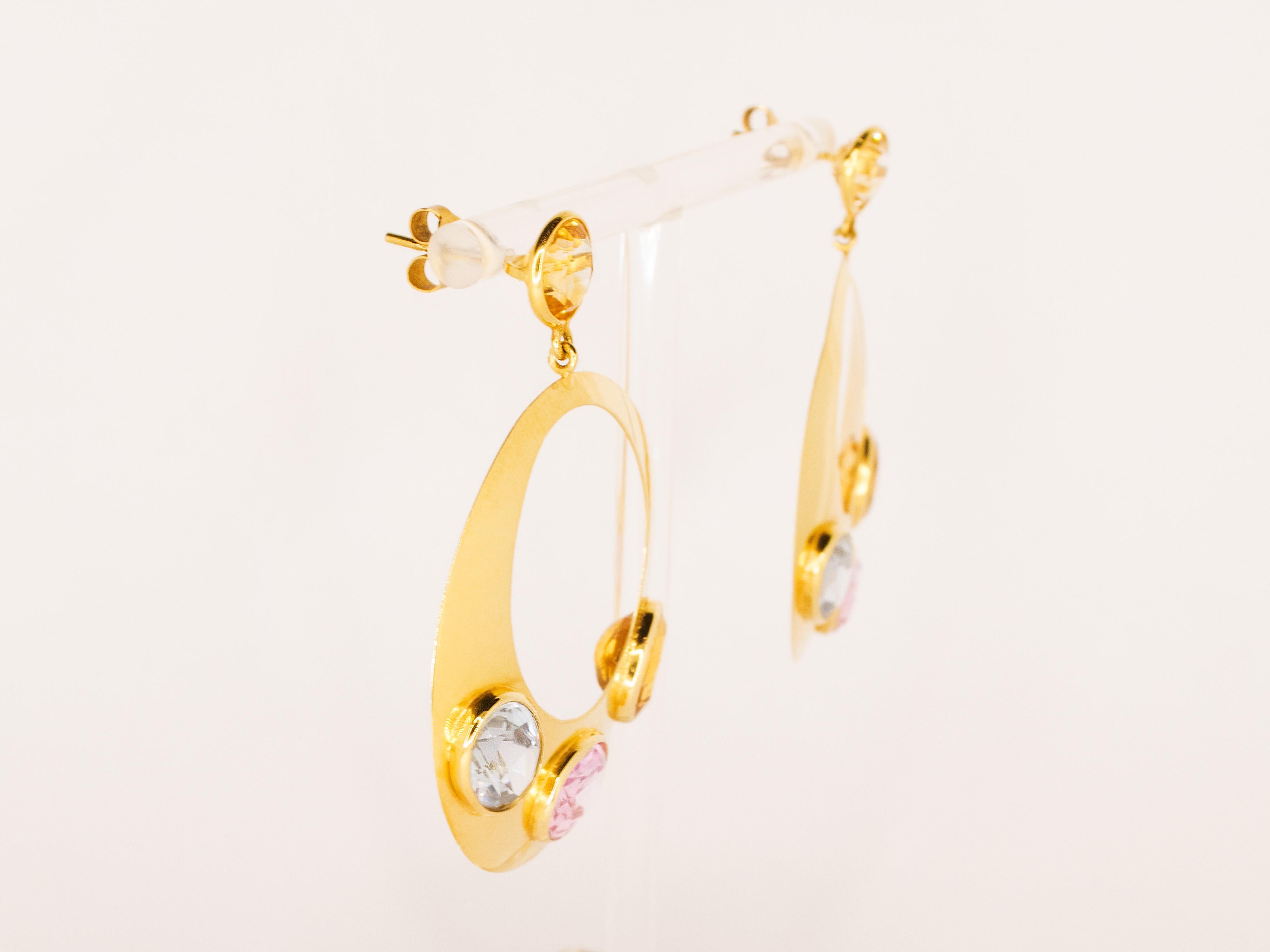 A pair of 18 kt yellow gold earrings weighing 14.80 g and embellished with  blue, pink and yellow quartz of oval and round cut.
These earrings have a 1990s style and design and at the same time are very current and wearable for any occasion.
Gold