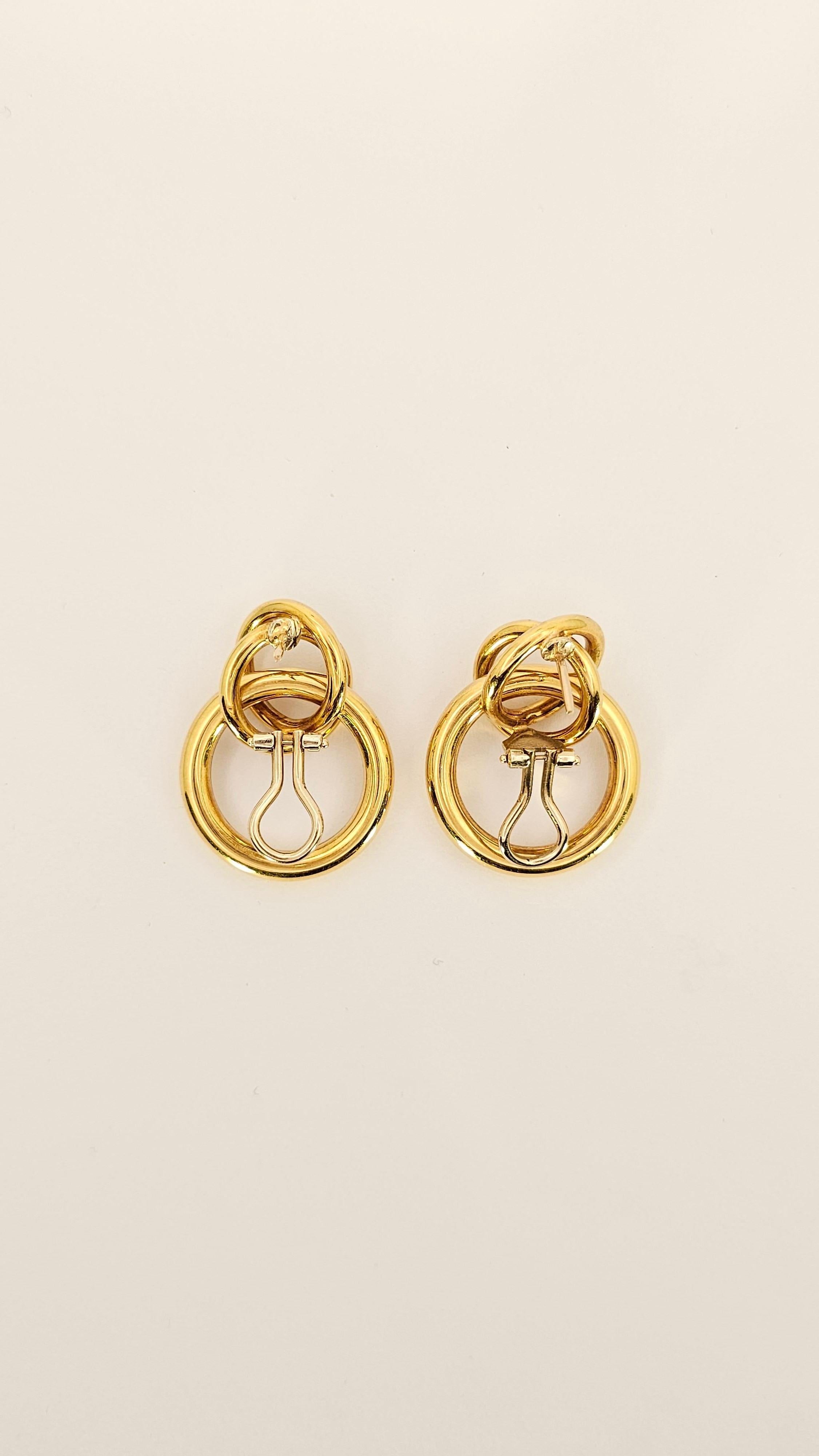 Un paio di orecchini realizzati in oro giallo 18Kt dal design tipico degli anni '80.
Questi orecchini sono composti da tre cerchi che si intrecciano tra loro.
Il cerchio più grande ha un diametro di 27 mm 
La lunghezza totale è di 33 mm.
La doppia