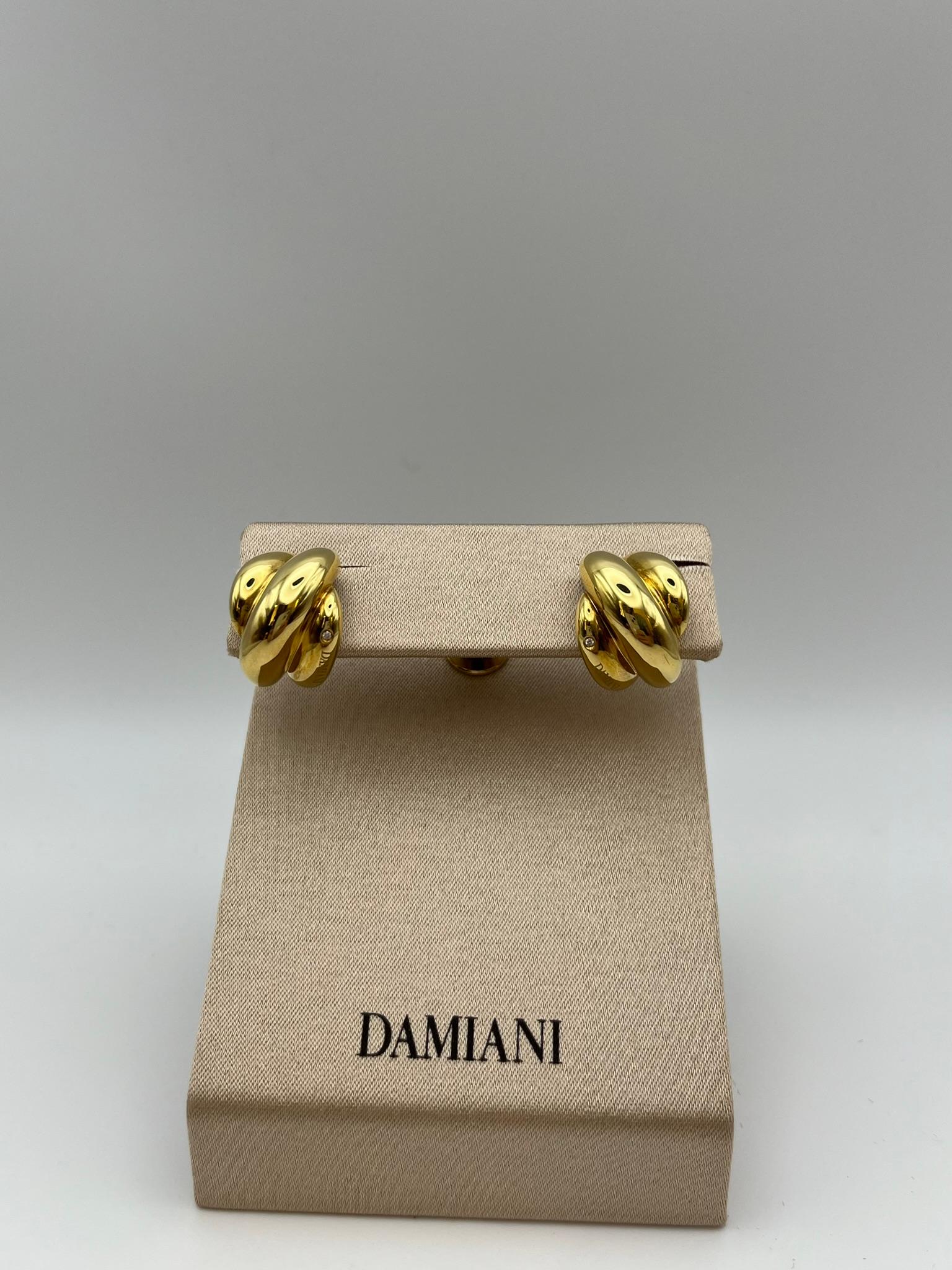 Boucles d'oreilles de la collection Damiani Gomitolo en or jaune 18 carats avec des diamants taille brillant d'un poids total de 0,02 ct. Les bandes entrelacées rappellent la figure d'une pelote de laine. Design conçu dans les années 1980. Elles ont