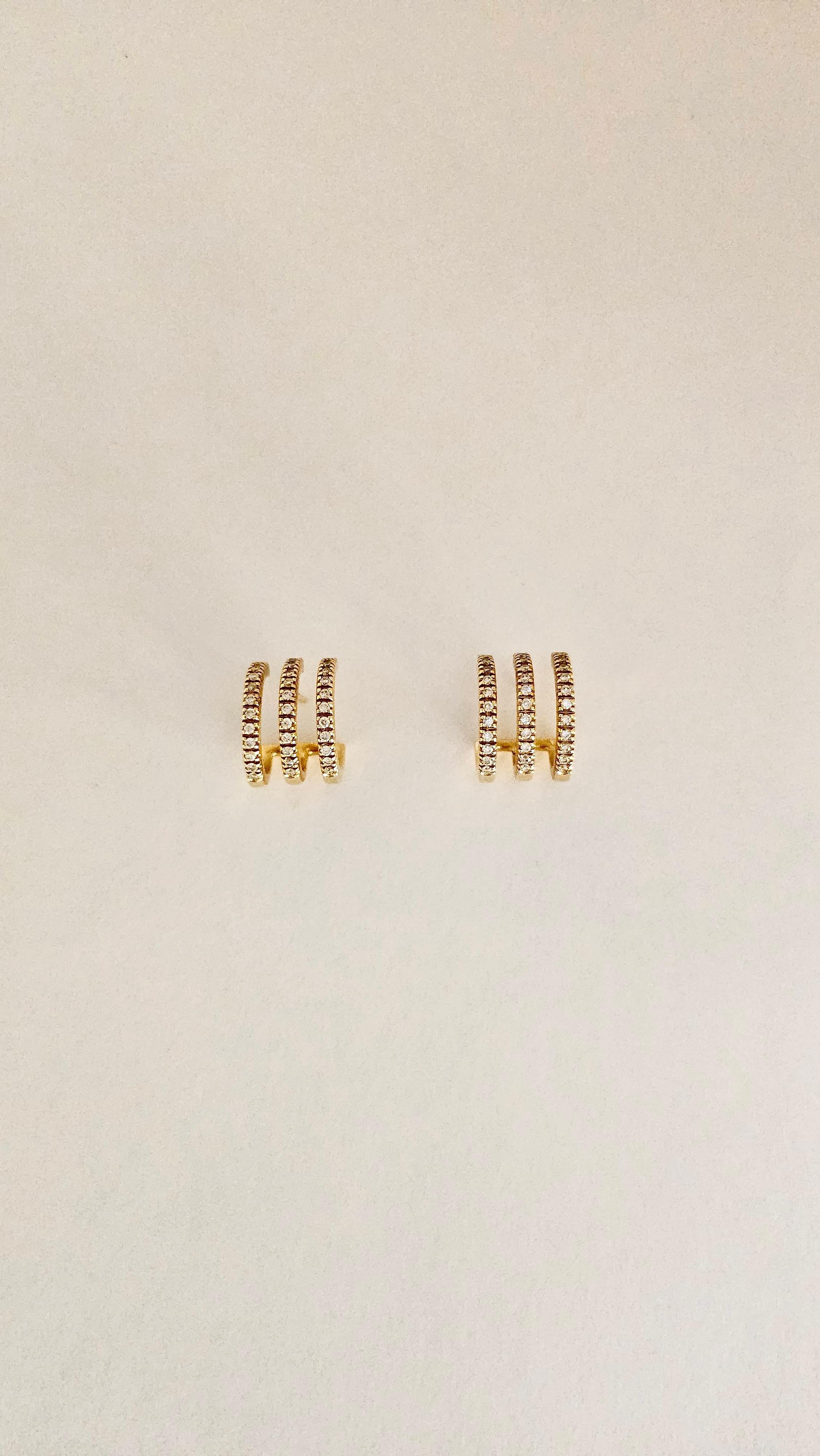 Une paire de boucles d'oreilles originale au design contemporain.
Cette médaille à triple cercle est en or jaune 18 carats et pèse 8,70 grammes.
Chaque cercle qui compose le motif est orné de diamants blancs taillés en brillant pour un total de 0,51