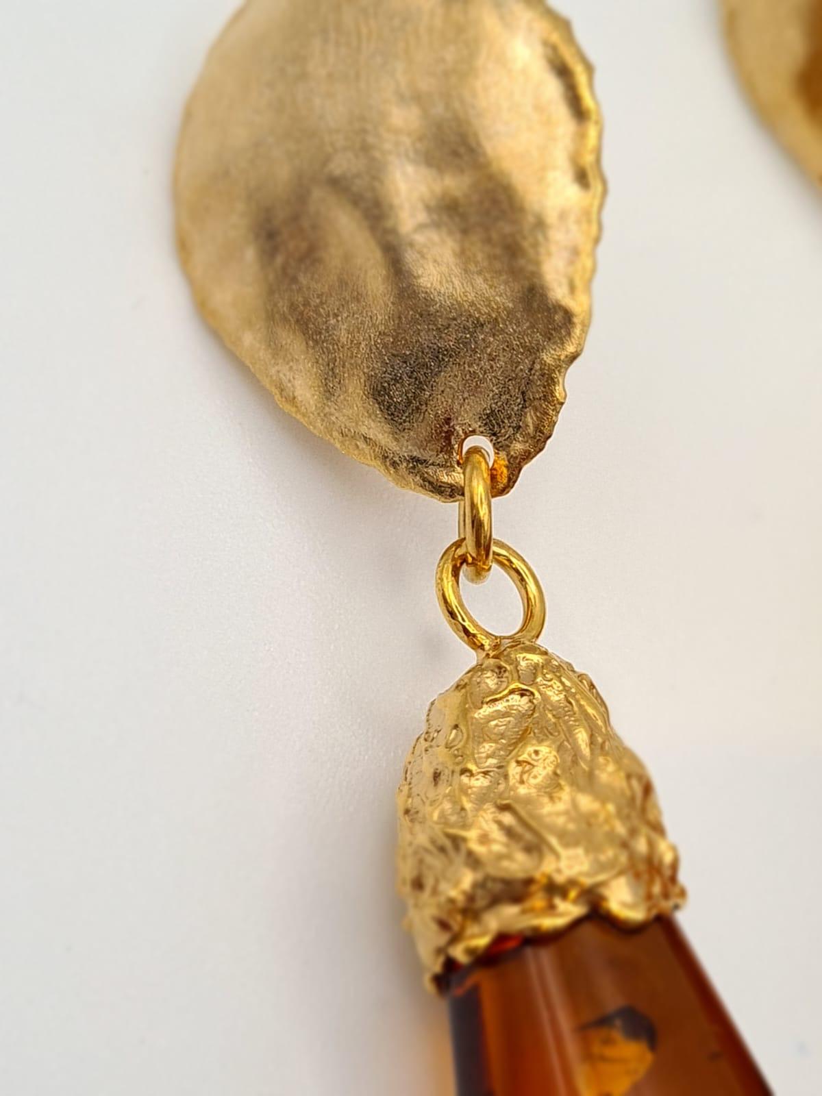 Orecchini realizzati in Argento 925 placcati in Oro 24 carati, con l'antica tecnica della Cera Persa (microfusione) con Goccia di Ambra Baltica color Cognac. Questi orecchini evocano un’ ancestrale bellezza, quella dell' Ambra Baltica che ha un'età