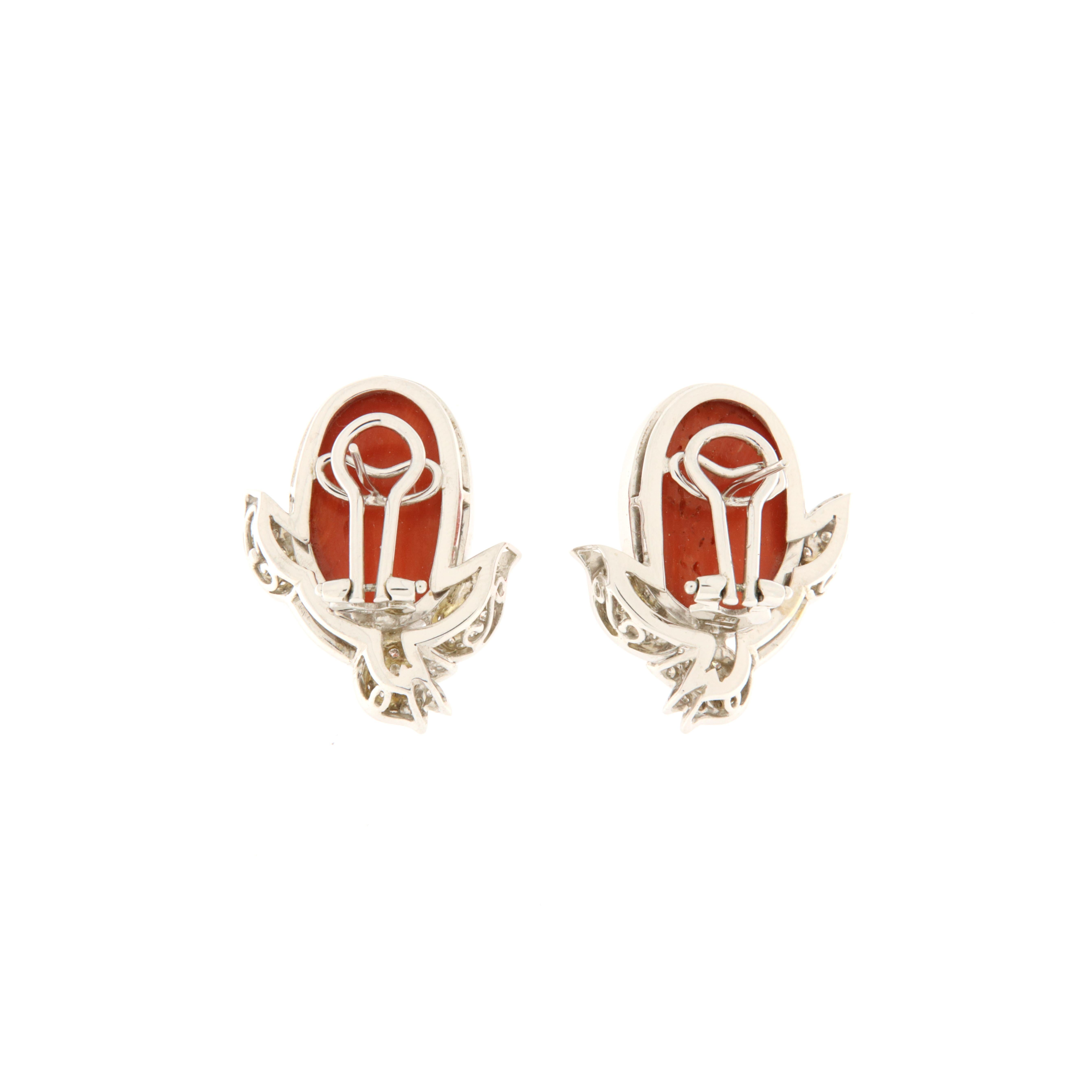 Pendientes de oro blanco con cabujón ovalado de coral rojo y decoración de tulipanes y hojas realizada con brillantes blancos (ct.0,63). Fabricación italiana, pieza única. Se desgasta bien en el lóbulo ya que el clip es muy alto. El coral tiene un
