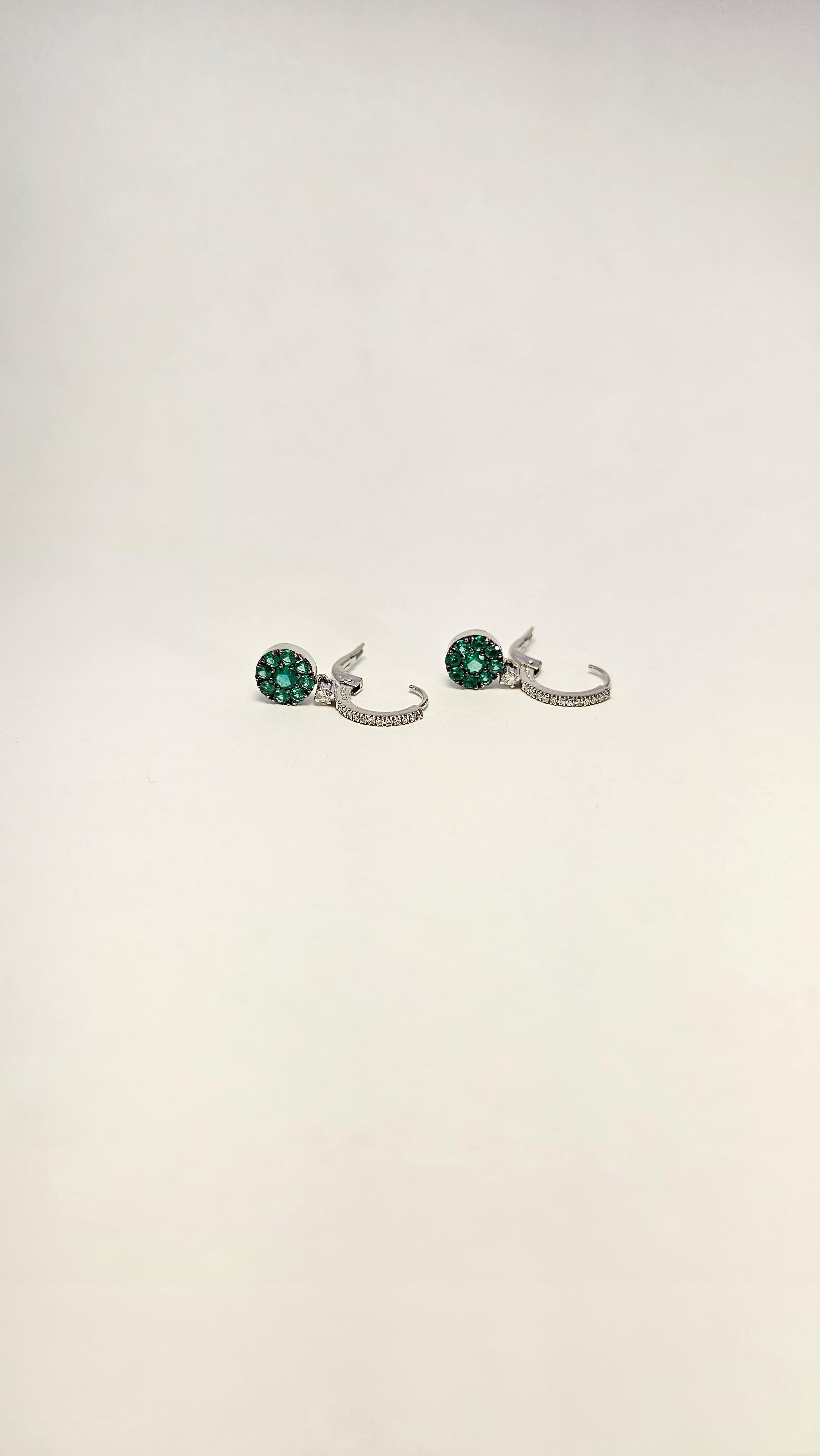 Gorgeous pair of 18kt white gold, Diamonds and Emeralds dangle earrings.

This model is made by a hoop top with Diamonds and lever closure.
The dangling part of the earring is composed of a round white gold tablet, embellished with multiple