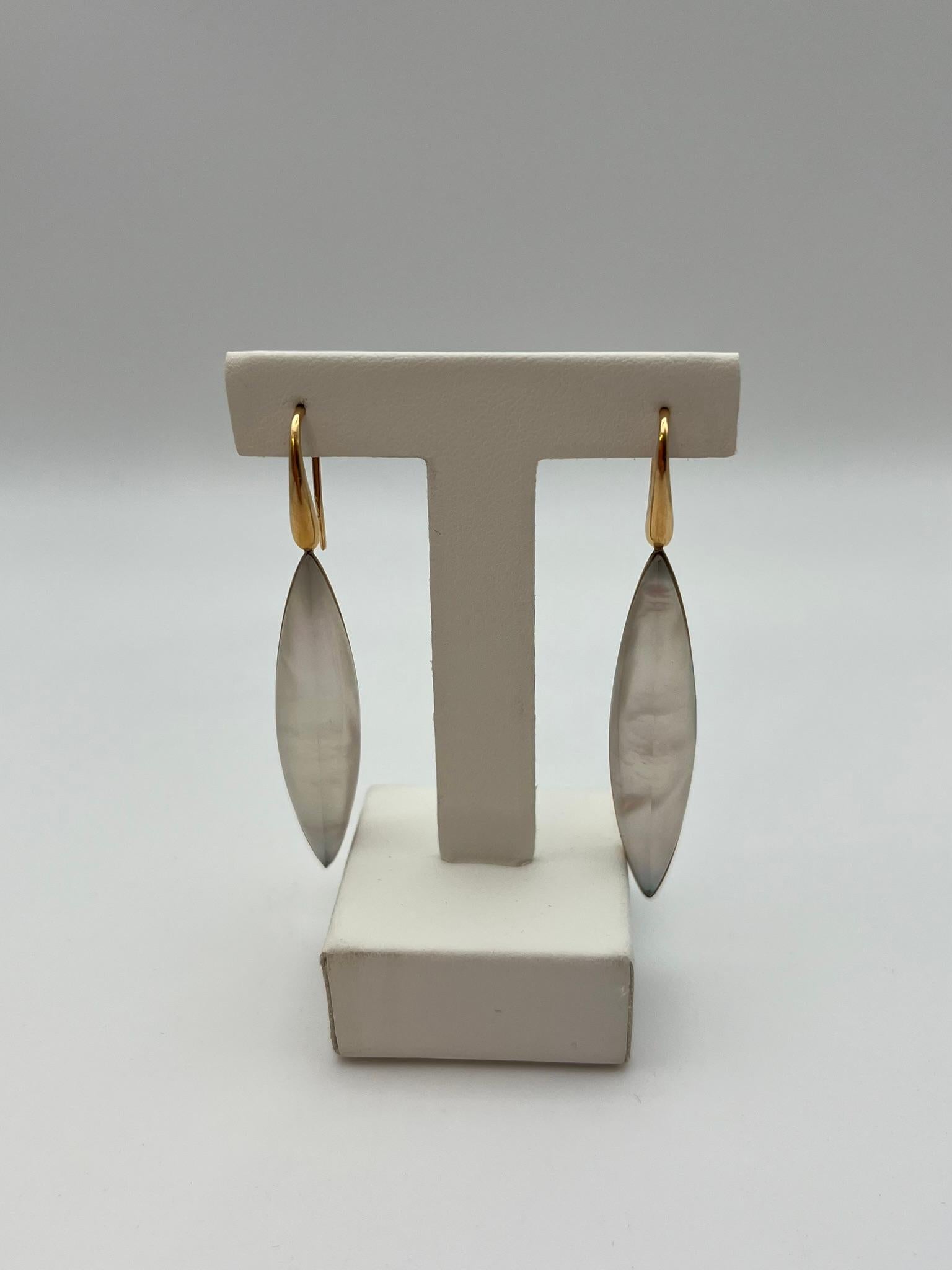 Raffinati orecchini pendenti di Fidia Gioielli Firenze, realizzati con la distintiva attenzione ai dettagli tipica della tradizione orafa fiorentina. Sono caratterizzati da un elegante inserto a forma di navette in madreperla naturale, incastonato