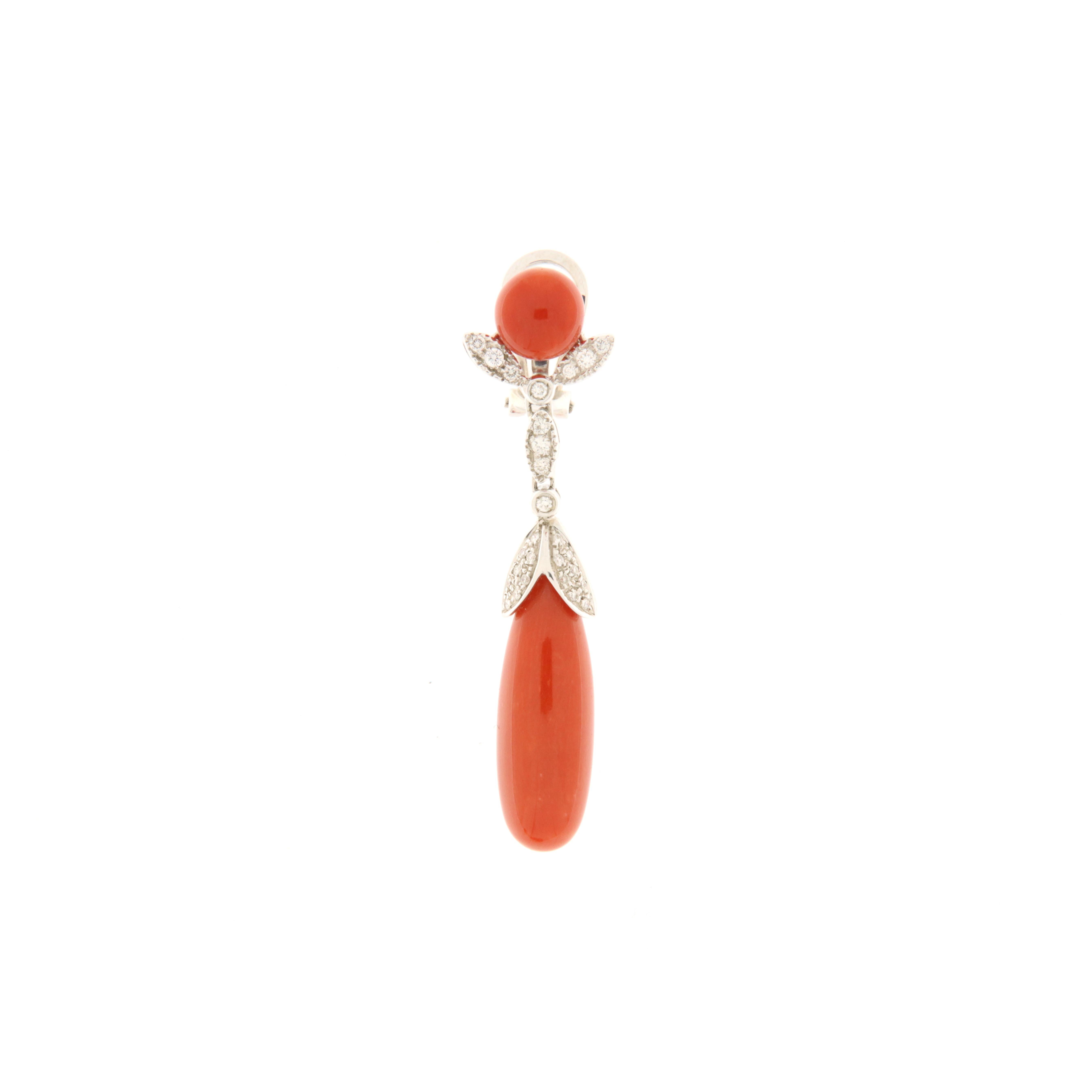 Dangling earrings made of 18 kt white gold. A round coral cabochon lobe from which white gold and brilliant (ct.0.58) decorative elements descend, ending in a beautiful red coral drop. The corals are from the Mediterranean Sea. This is a piece of