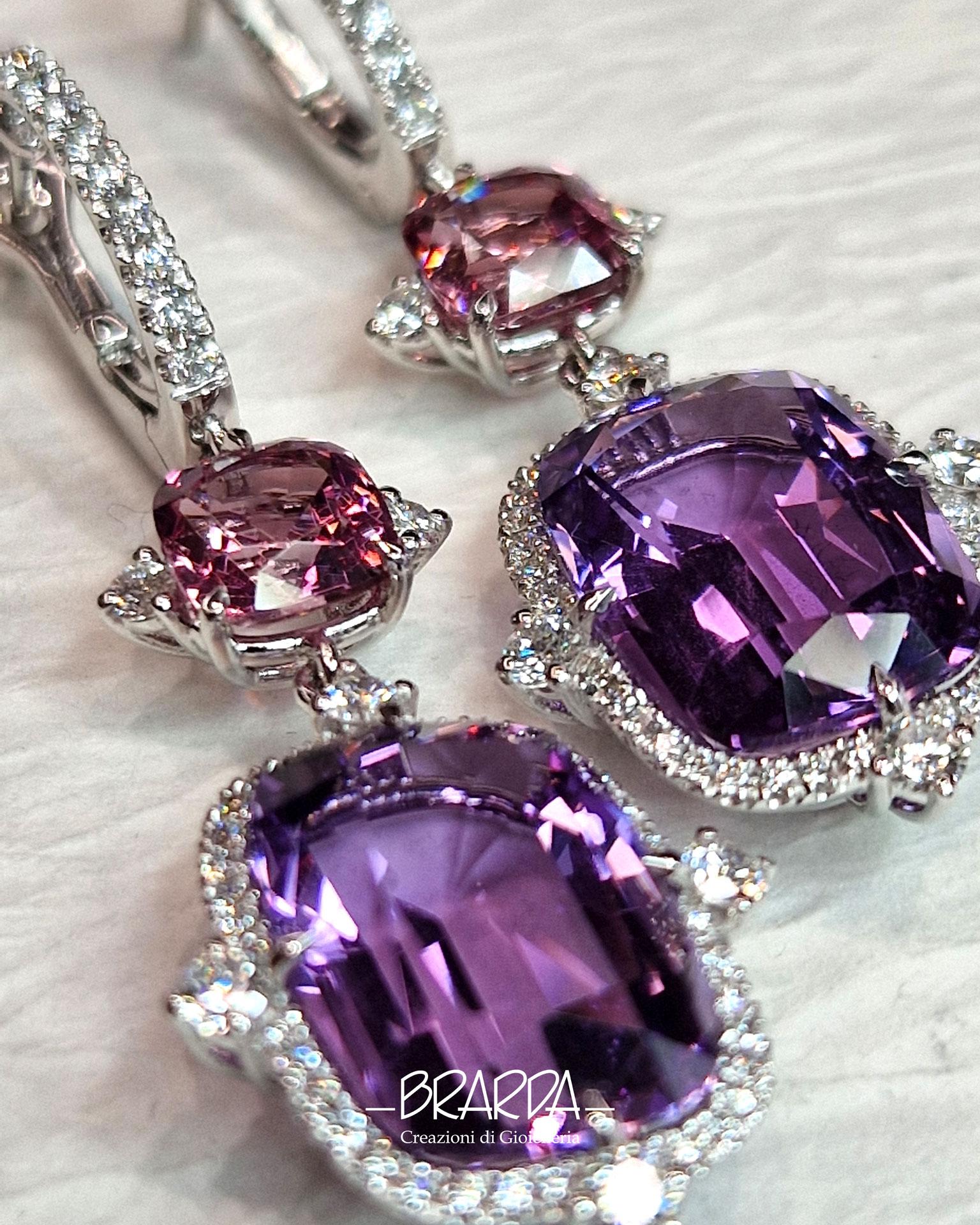 These earrings are the result of reasoning about the interplay of color shades. This version, entirely in 18kt white gold, sees as its color note a pair of more pinkish tone Malaya Garnets (cushion cut ct 3.57 total) paired with a pair of clear