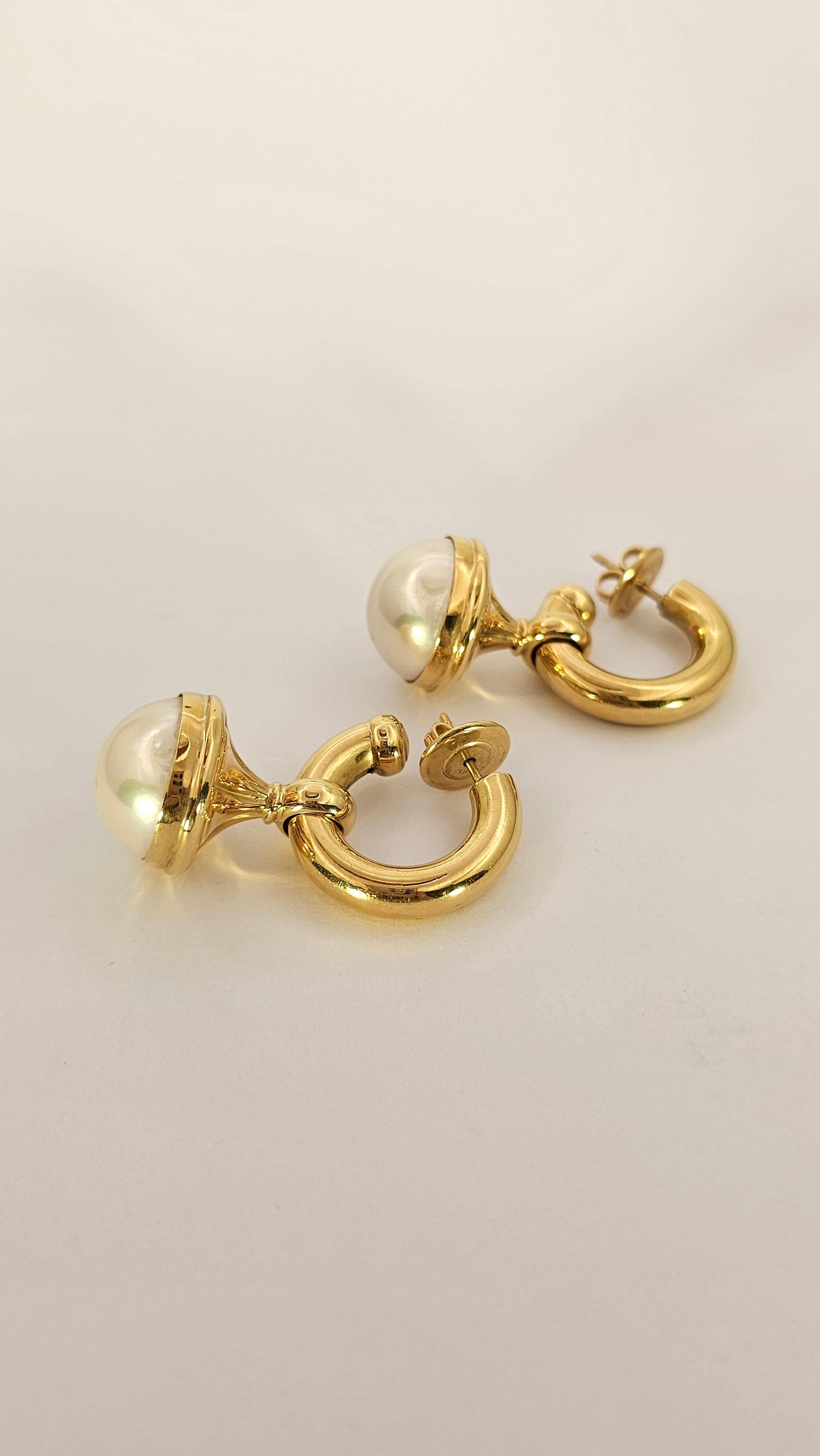 A vintage, 1980s-era pair of earrings made of 18kt gold.
Composed of a convex circle top with a diameter of 25 mm and thickness of 5 mm.
The lower part consists of a removable pendant made of gold and Mabé pearl ( freshwater pearl ).
The closure is
