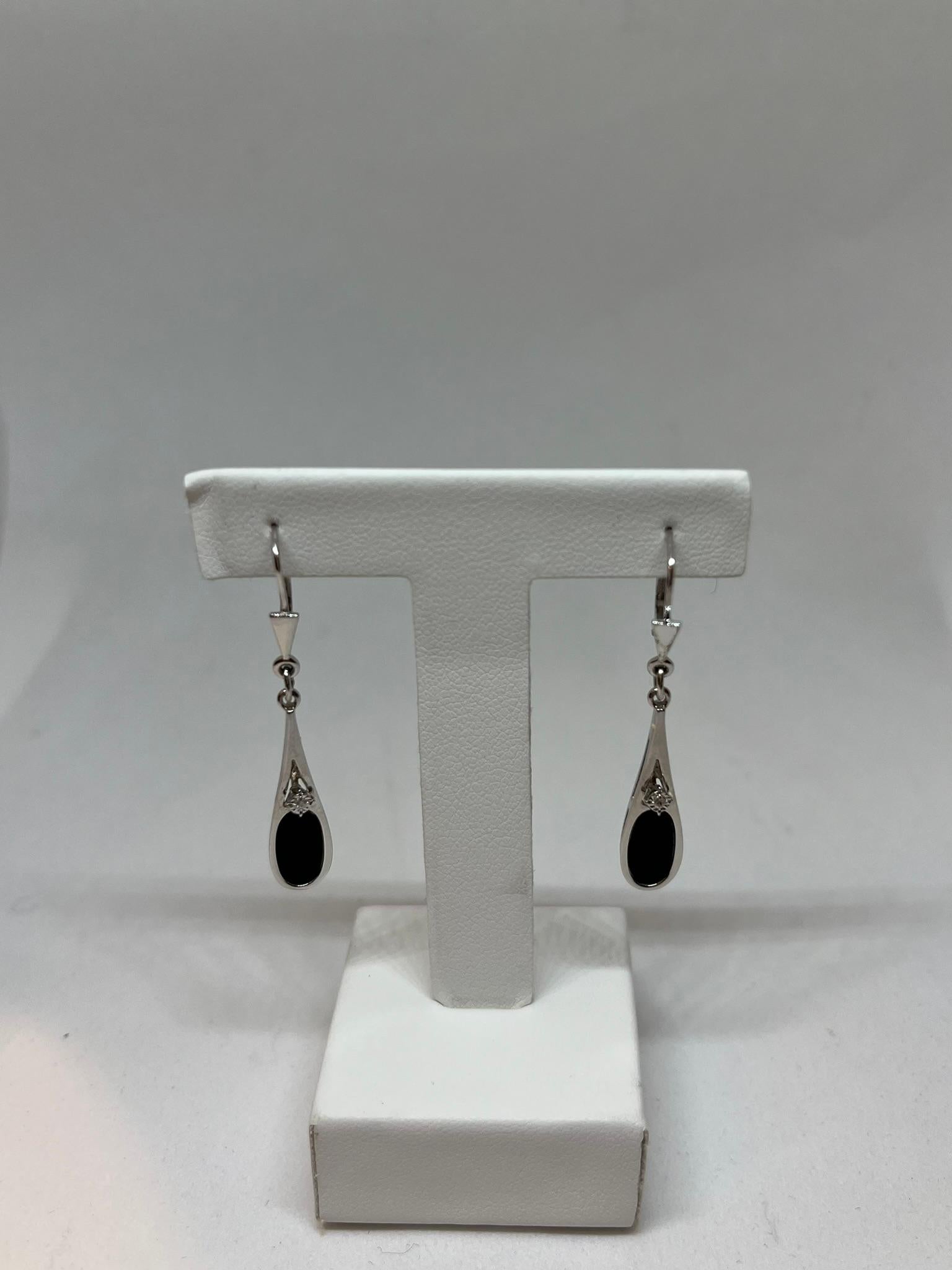Estos pendientes vintage de principios de siglo tienen un diseño atemporal. Presentan un ónice  con una talla oval engastada en una montura de oro blanco de 9 quilates que sigue su línea, dándole más ligereza. En el centro del pendiente hay