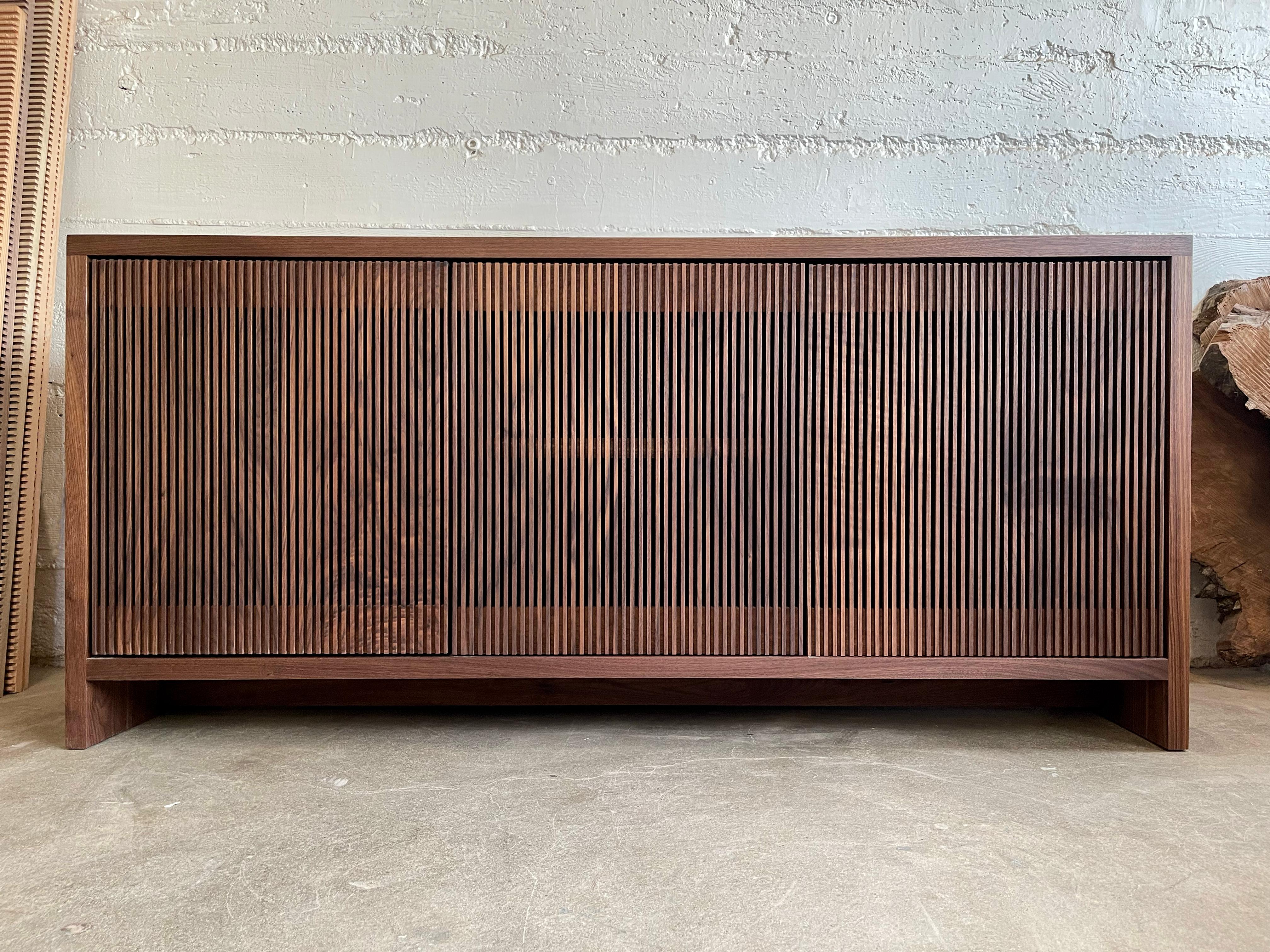 Crédence ou buffet en noyer noir massif avec portes à lamelles en bois délicieusement ouvragé. Conçu et fabriqué dans l'atelier de Material Architecture à Portland, dans l'Oregon. Les portes sont assorties au grain pour célébrer la beauté du noyer