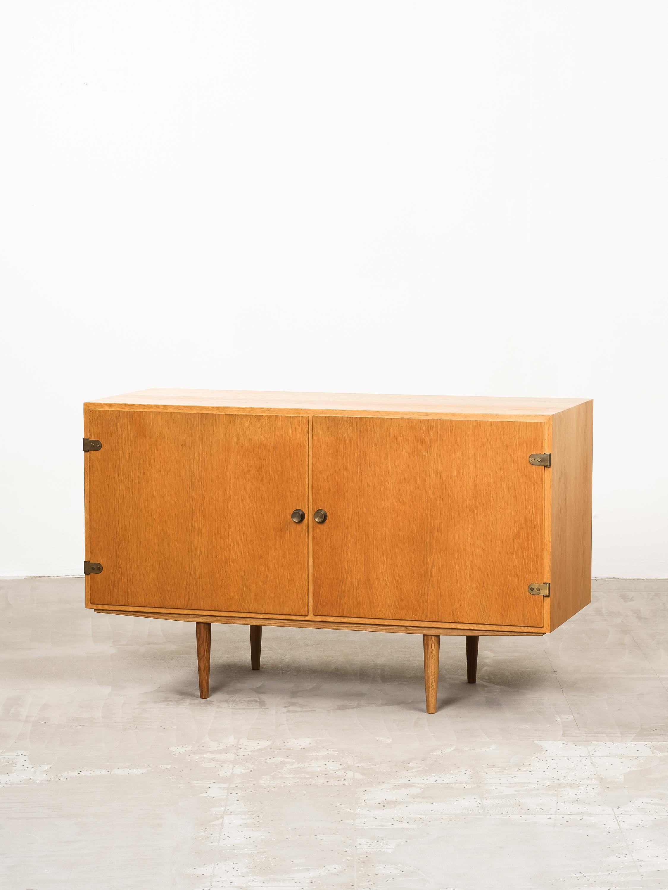 Børge Mogensen per Karl Andersson & Söner, mobile 'Öresund' in Oak con dettagli in ottone, Danimarca, anni '60

Una credenza ordinata e semplice disegnata dal maestro danese Børge Mogensen negli anni Sessanta. Il pezzo contiene una forma cubica