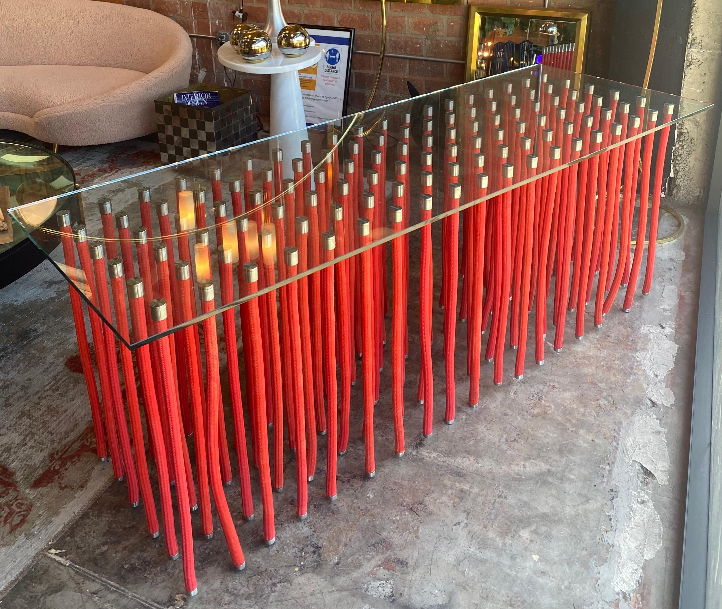 A tall red ORG table designed by Fabio Novembre (Italian, born 1967) in 2001 for Cappellini. Made of glass top supported by polypropylene rope-covered steel with exposed stainless-steel fitting. The table appears floating on the air due to the