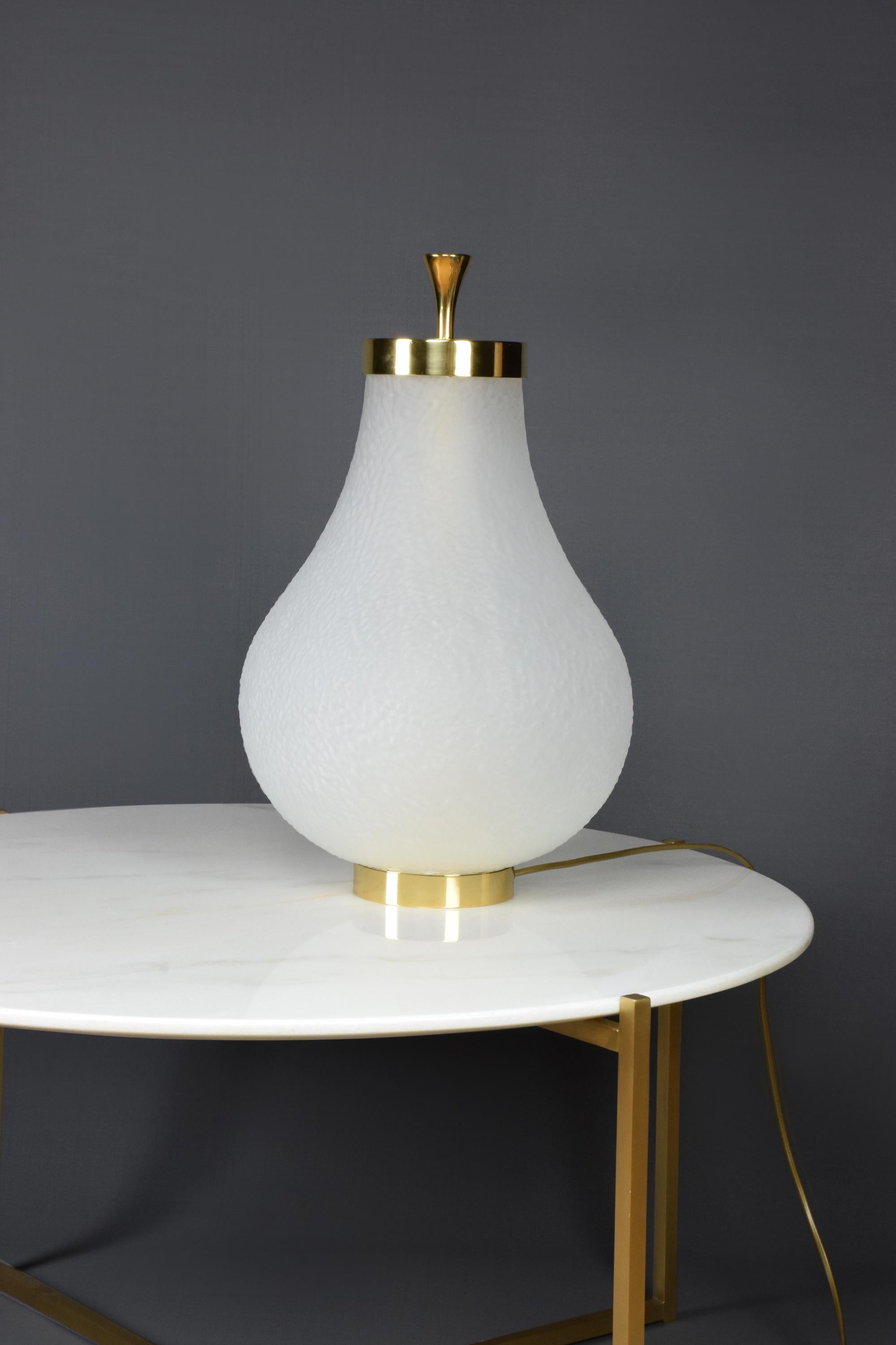 An accent table lamp designed with an organic frosted textured glass shade and brass details which diffuses a warm light all around.
1x60 W max E27
230 V - LED integrated
120 V - LED.

Flow 2 by JA Studio 
The inspiration behind this collection was