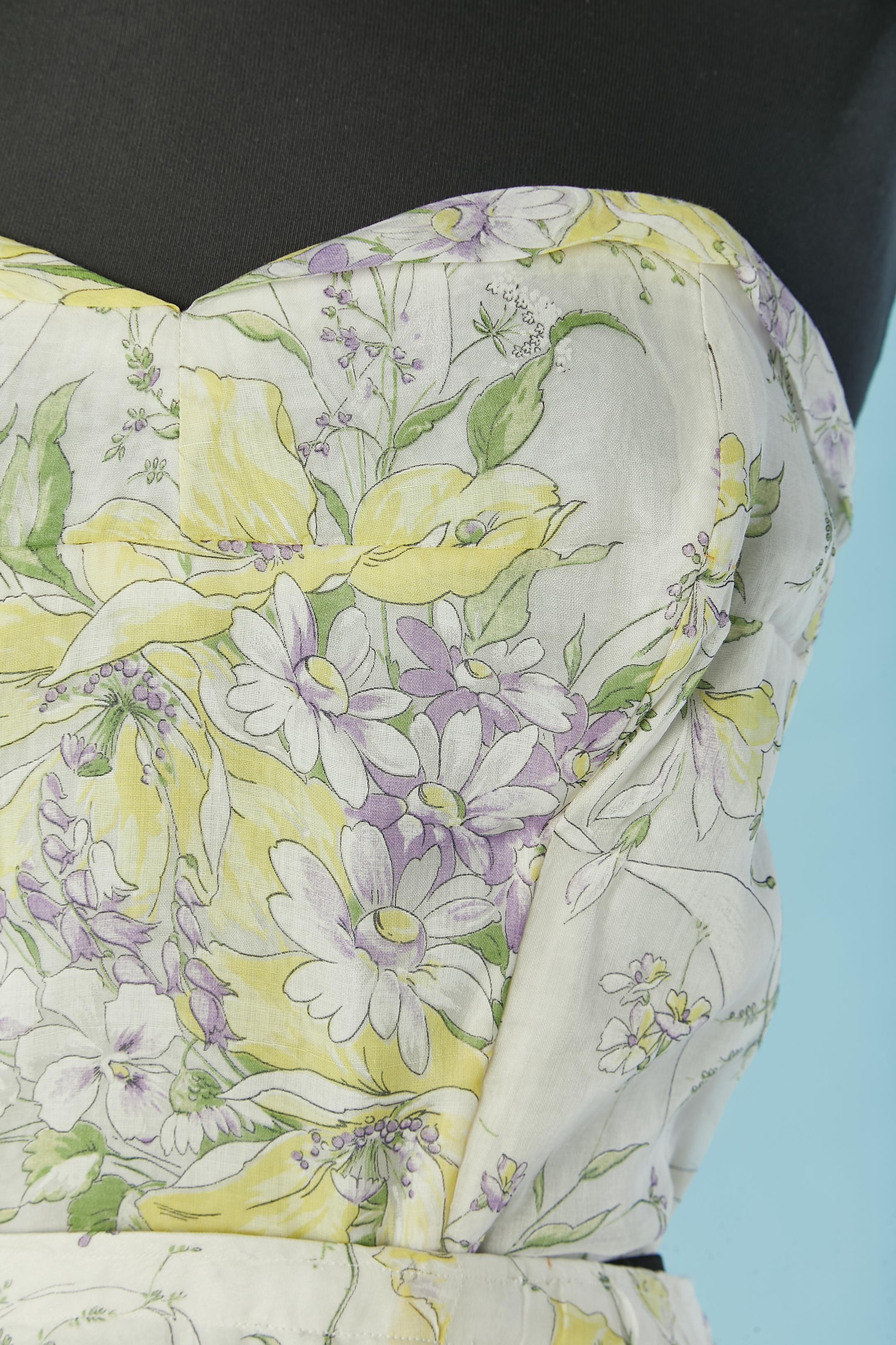 Ensemble bustier et jupe en organdi avec imprimé de fleurs pastel. 
Il n'y a pas d'étiquette de composition du tissu mais la doublure est probablement en rayonne. Le bustier est désossé et se ferme au milieu du dos par une fermeture à glissière et