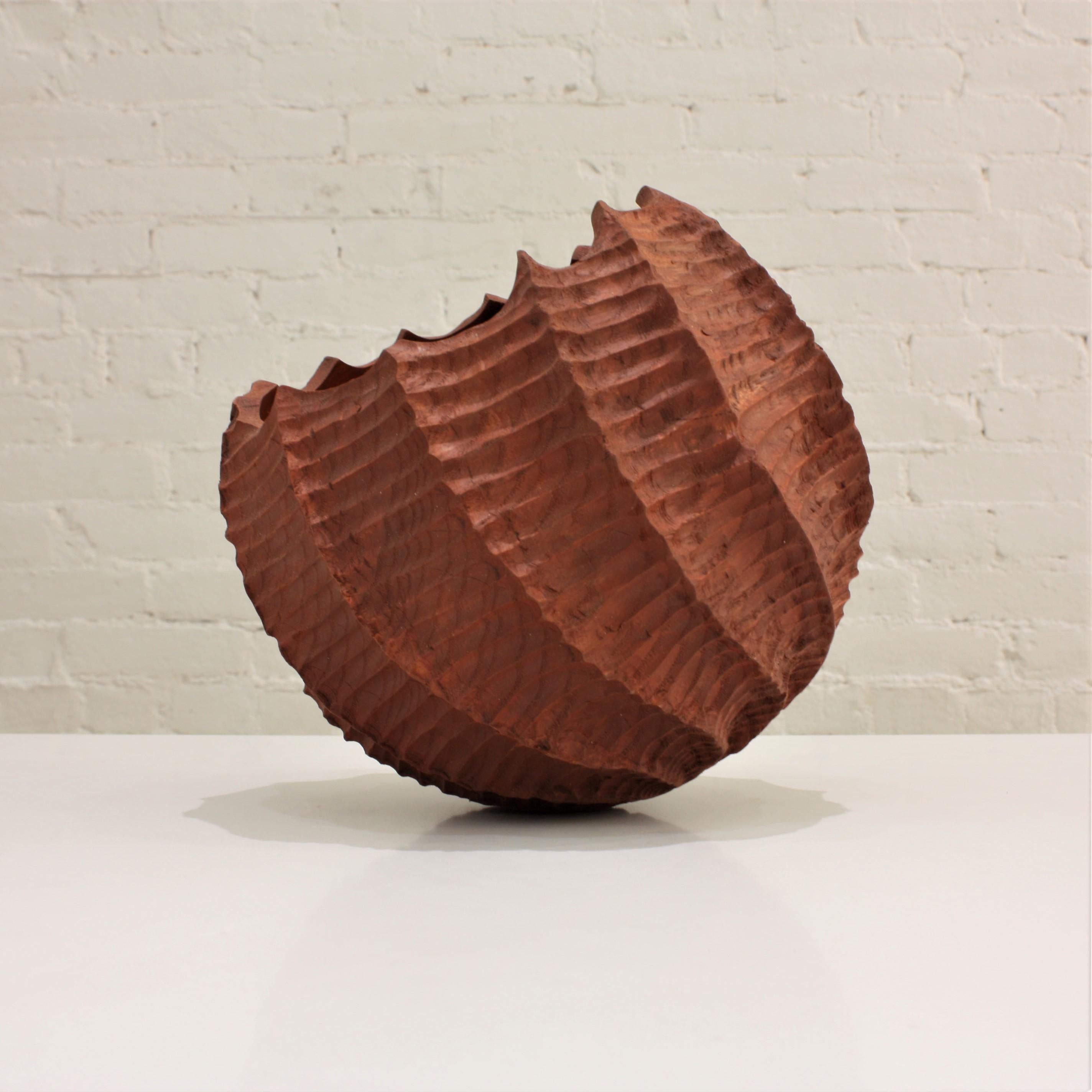ashwood sculpture by artist Maxime Perrolle in warm cinnamon tones. The combination of textures is particularly strking, with its smooth interior and rugged outer surface, and extendes an invitation to touch. This piece was created out of a single