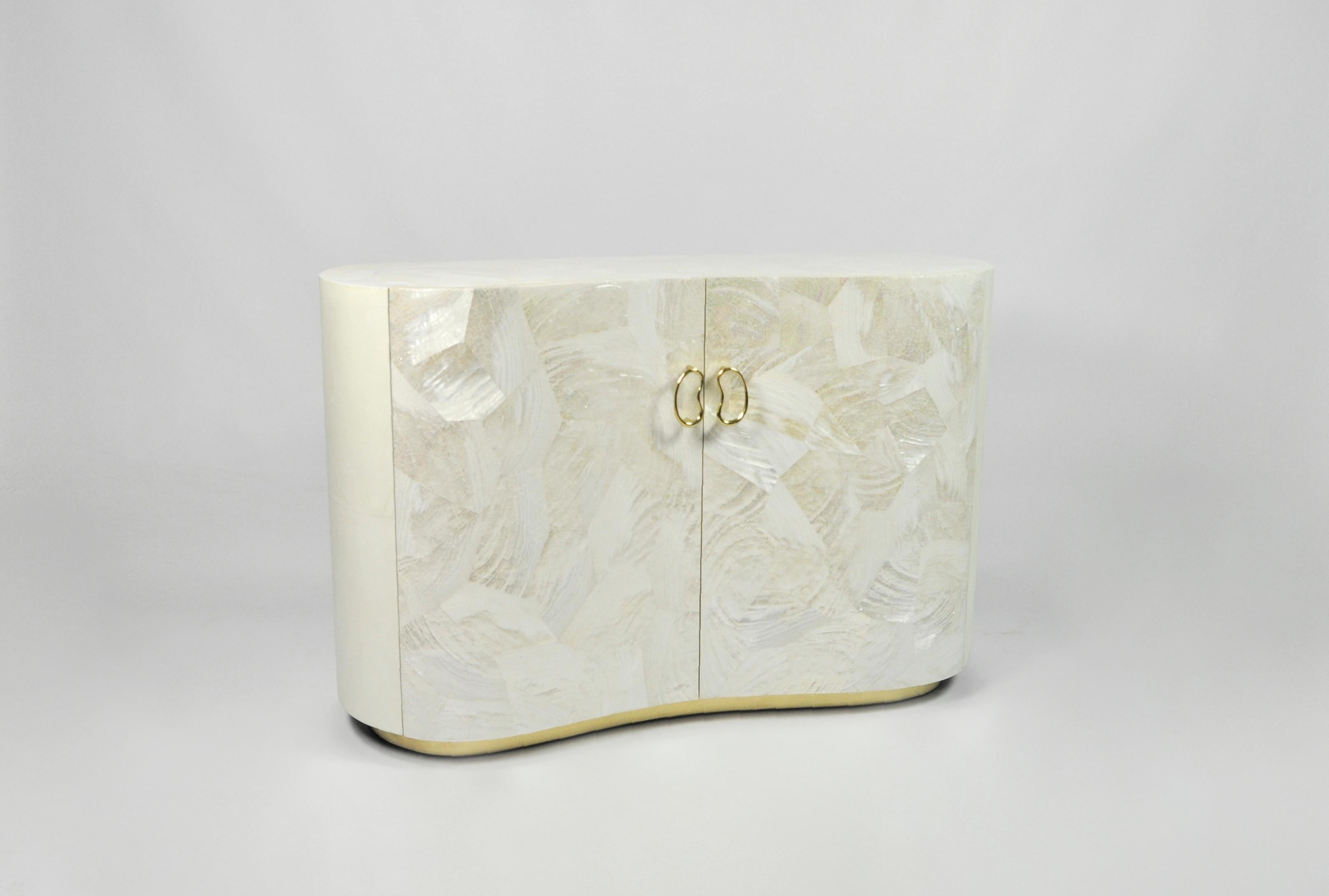 This beautiful nightstand table is made of ivory parchment with a gilded base.
It has 2 doors made of polished white marquetry.
The organic design knobs are made in lost wax cast brass.

The dimensions of this piece are W39.37