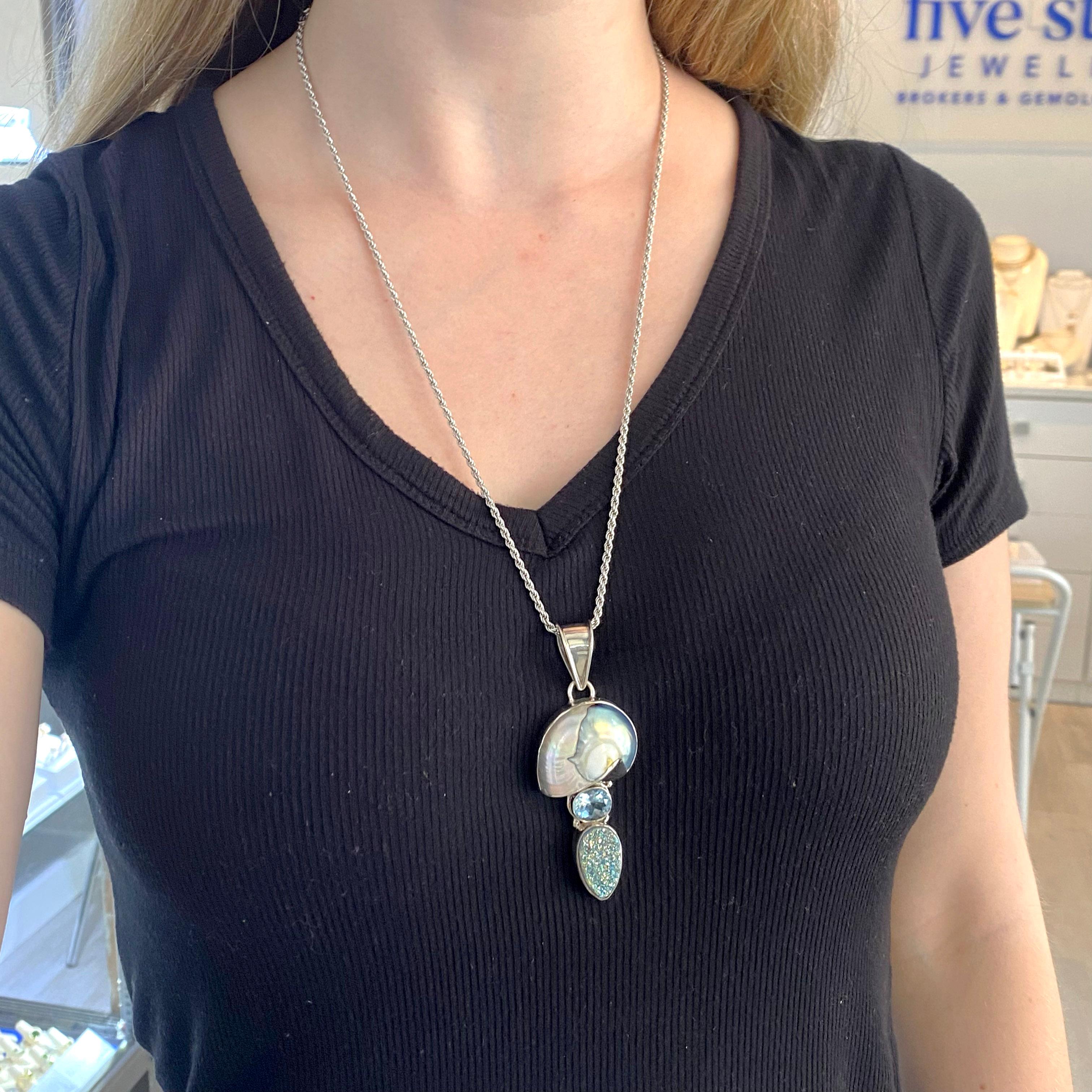 Der organische Anhänger hat eine Nautilus, die in der Farbe irisierend ist, blauer Topas horizontal gesetzt, drusy, die birnenförmig ist und alle in handgefertigten Sterling Silber Lünette mit einem großen Bügel auf der Oberseite gesetzt.   Es ist