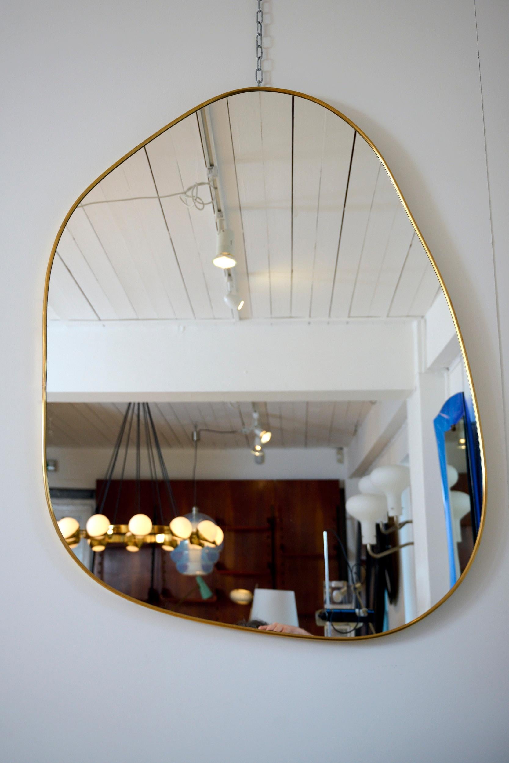 Contemporary curved organic mirror with brass frame.

The design is the Italian brass frame mirror style of the 1950s but with a modern organic form. 

Larger and smaller versions available.