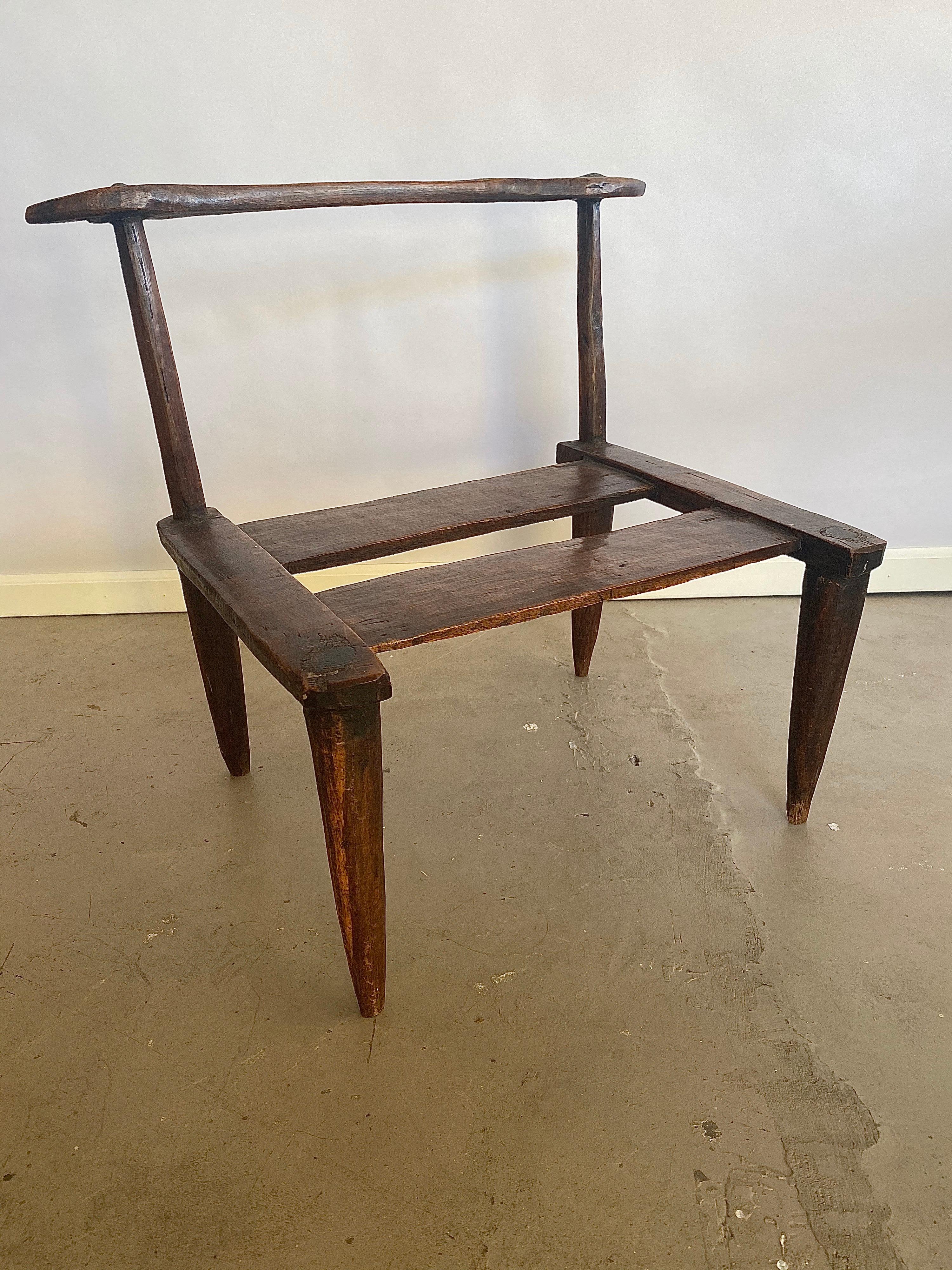 Beautifully master-crafted and highly decorative dark wood low side chair or stool. This piece is made in a very organic natural way without the use of any iron nails, only wood-in-wood joints. It has several  features -like the crescent-moon shaped