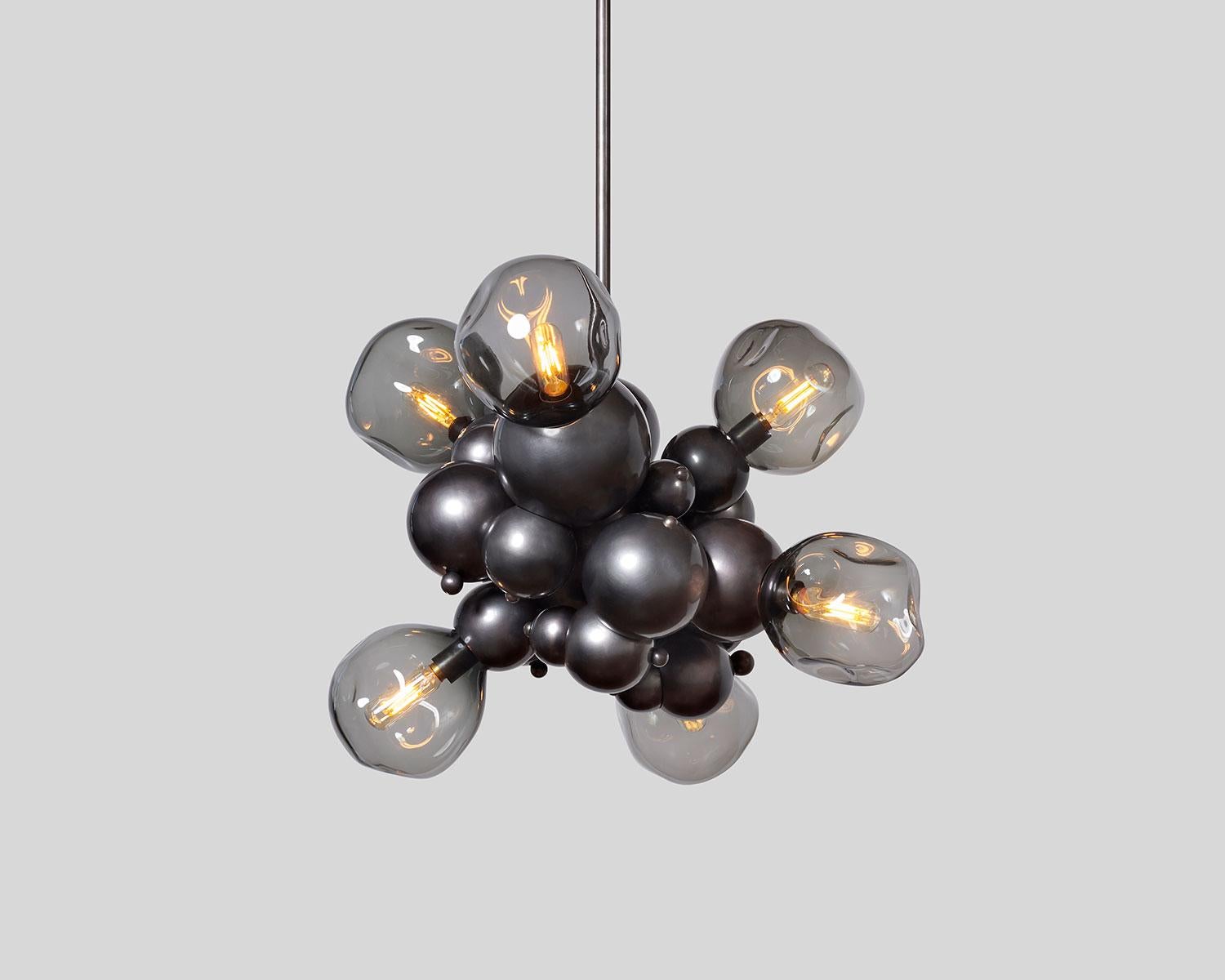 Organic mid-size cluster chandelier or large pendant with six hand blown glass lights, designed from interlocking spun brass spheres. Inspired by soap bubbles and botryoidal hematite, Rosie Li's 