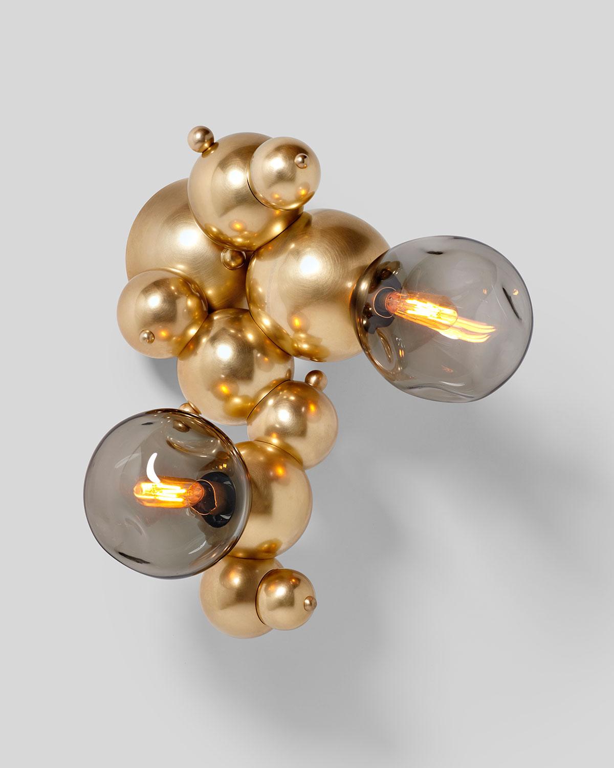 Organic, sculptural cascading sconce with two hand blown glass lights, designed from interlocking spun brass spheres. Inspired by soap bubbles and botryoidal hematite, Rosie Li's 