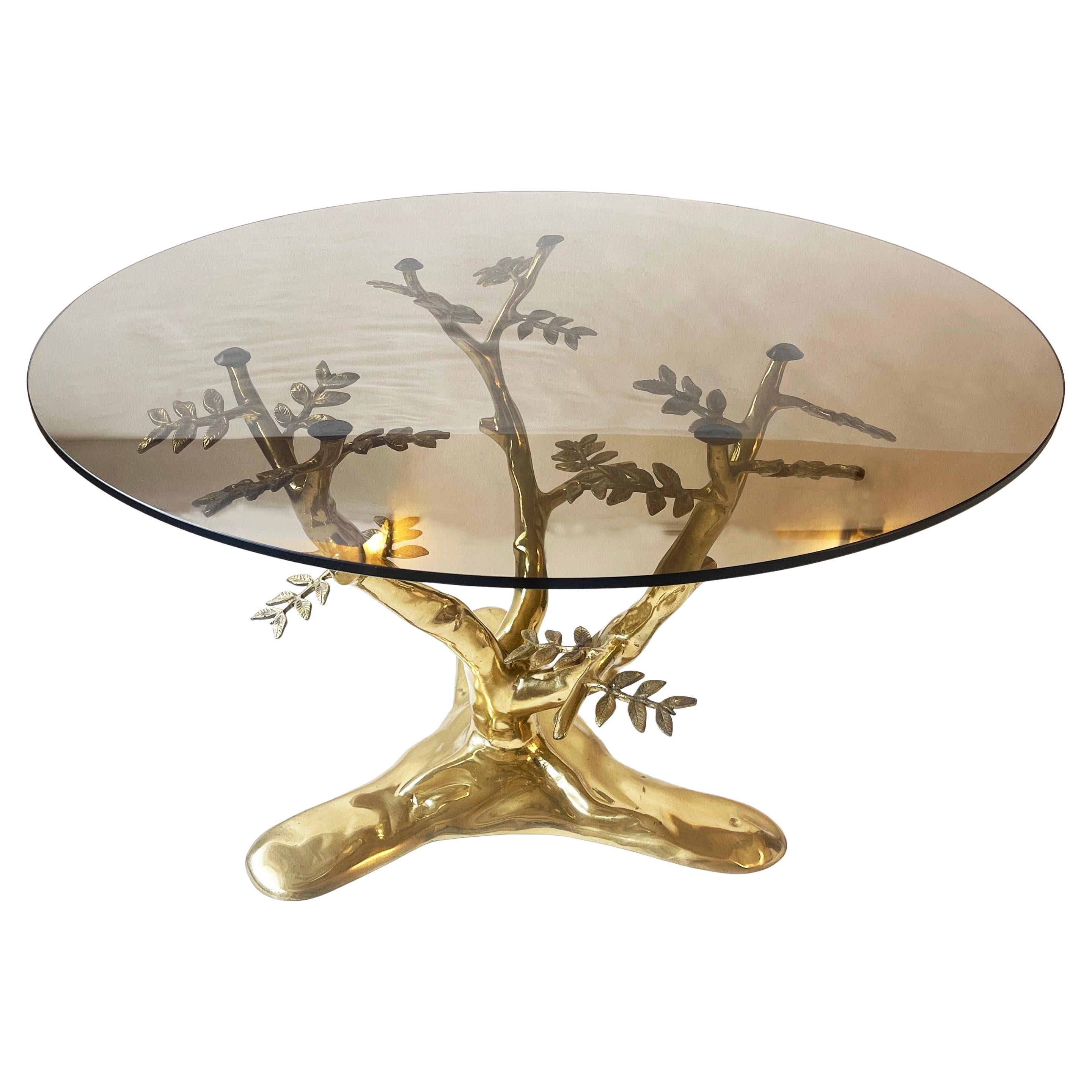 A beautifully designed coffee table in the manner of Willy Daro, circa 1975 – 1980.
A bit of Hollywood Regency and of course French modern.
Cast in brass, and handcrafted, the branches of the 'Bonsai' tree support the round brown smoked glass