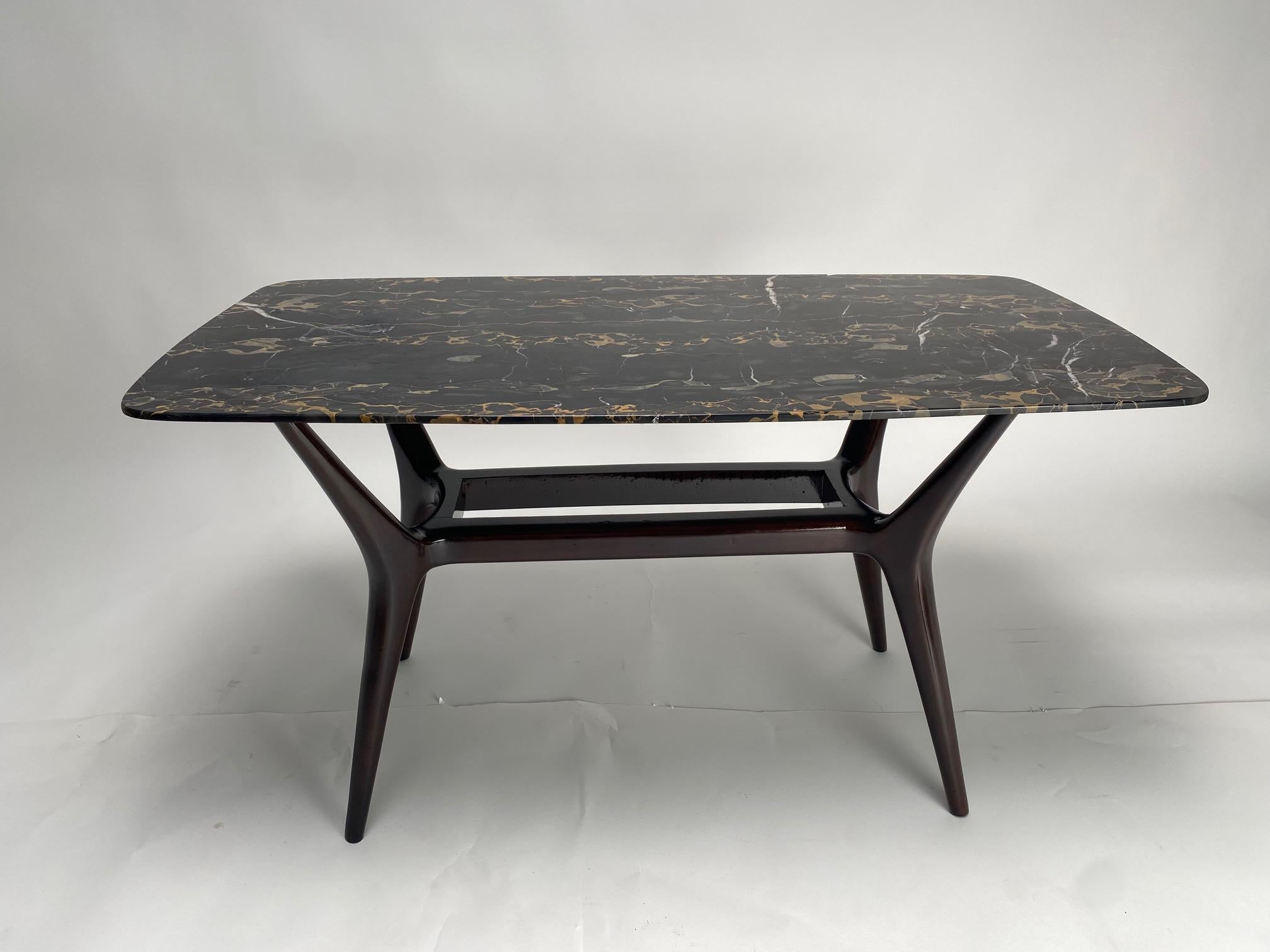 Rare et importante table basse du milieu du siècle dernier avec une structure en bois laqué et un épais plateau en marbre noir veiné. 
Fabriqué en Italie dans les années 1950 dans le style du grand architecte et designer Gio Ponti.
La structure a