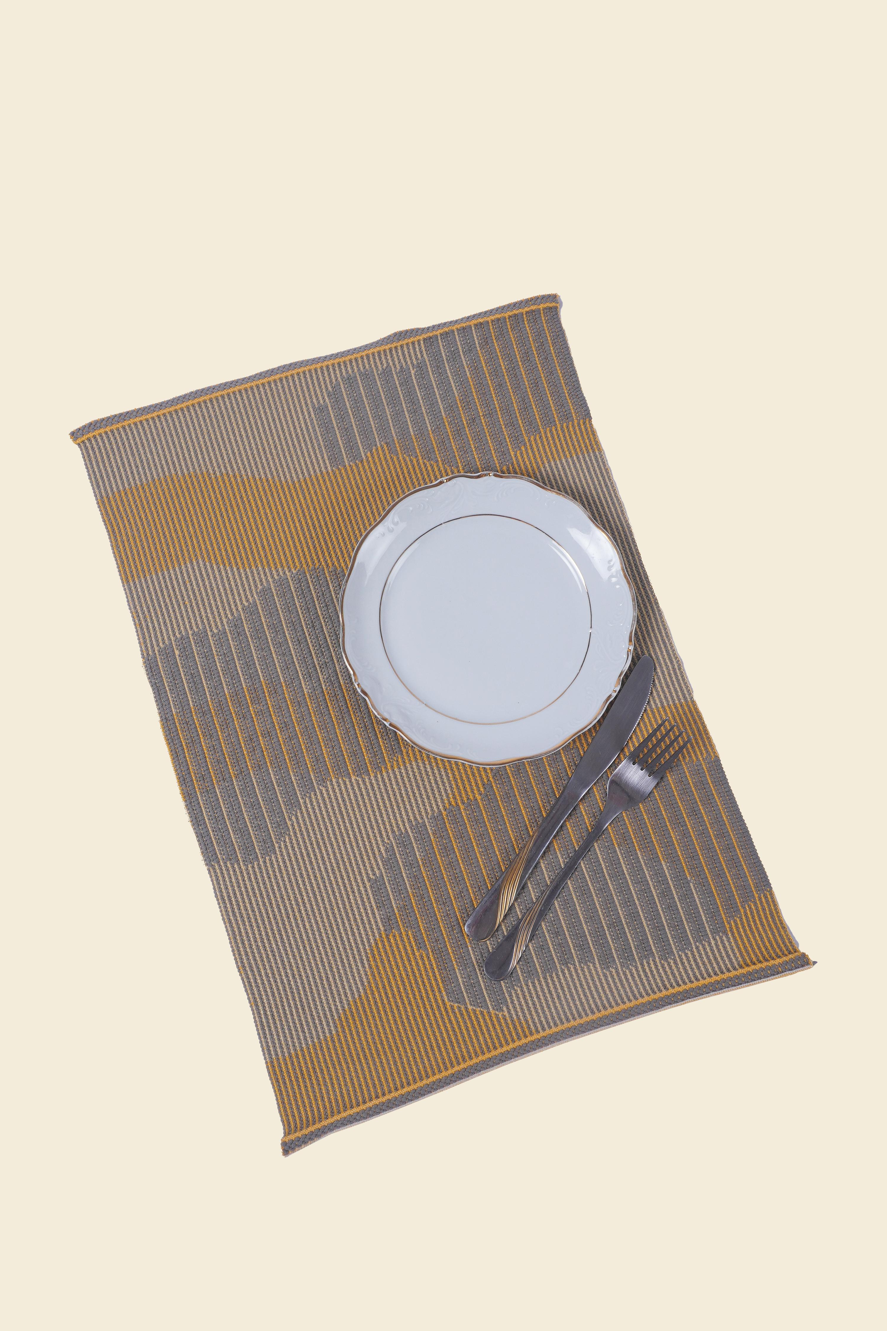 Mit seinem tonal gemischten, organischen Muster bringt dieser Tischuntersetzer Verspieltheit auf Ihren Esstisch. Die einzigartige Einlegegarntechnik verleiht diesem Stück eine gewebte Optik. Durch die Kombination von Stricken und Weben erhält das