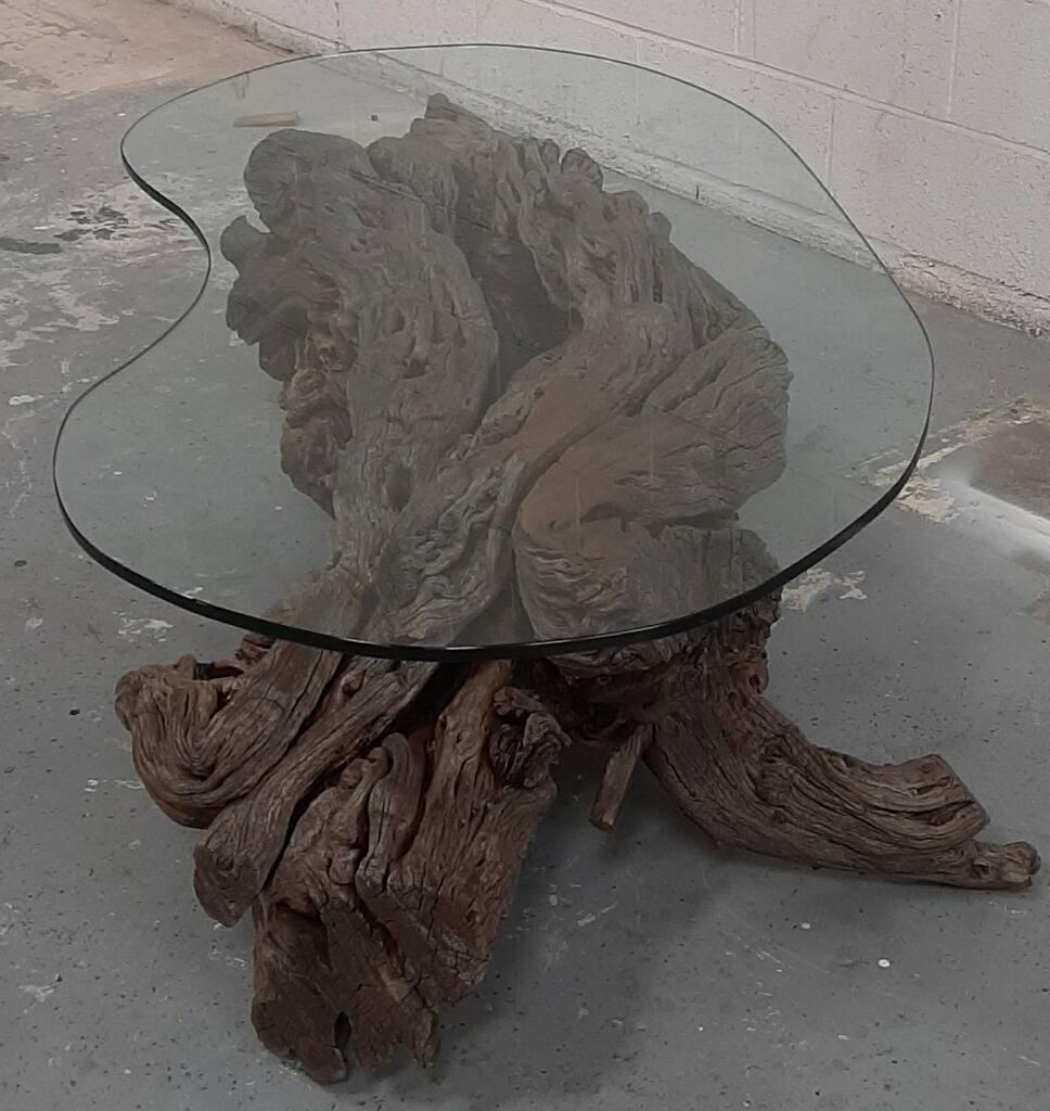 This stunning coffee table is a captivating fusion of natural artistry and modern design, making it an exceptional centerpiece for any living space. The base is meticulously handcrafted from intricately cleaned and polished California Pepper Tree