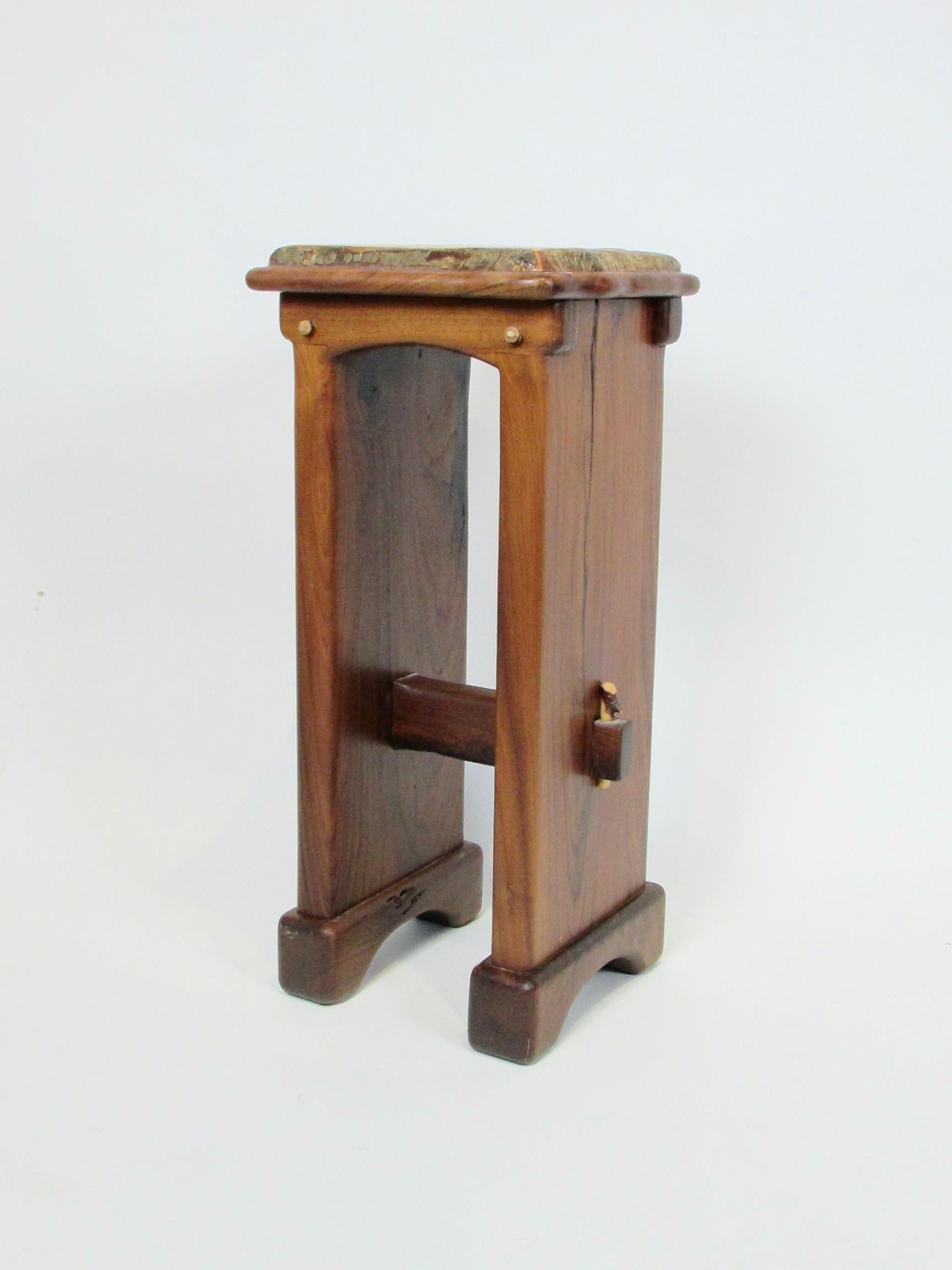 Solid walnut plant stand in craftsman studio style. Thick walnut sides with stretcher tenoned through each side natural twig type dowel inserted on the outboard side. Natural free edge style top.