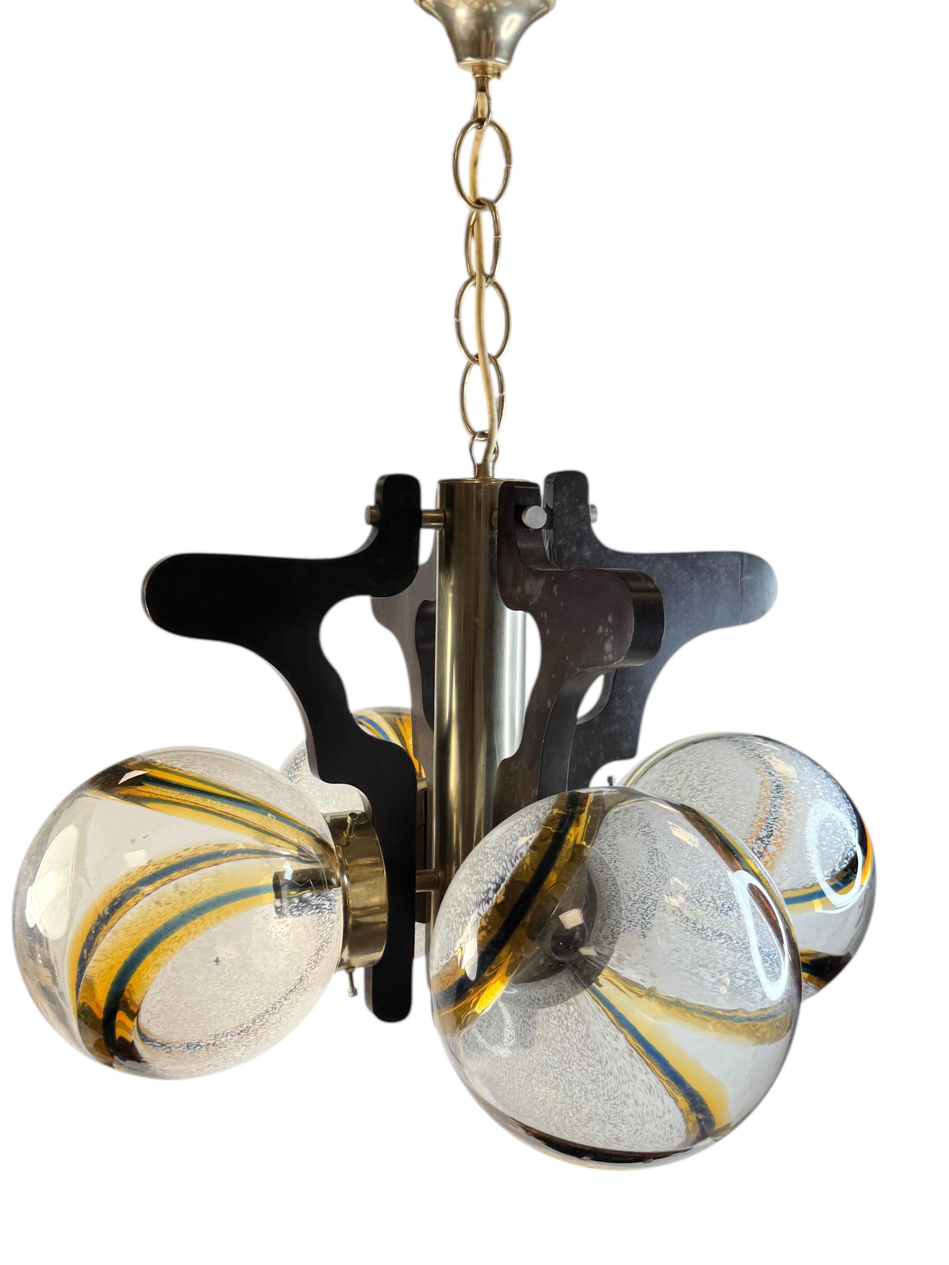 Gran bola de cristal con motivos orgánicos de mediados de siglo, de Mazzega, Italia. La luminaria requiere cuatro bombillas candelabro europeas E14 / 110 voltios, cada bombilla de hasta 60 vatios. Está hecha de madera ebonizada, metal, latón y