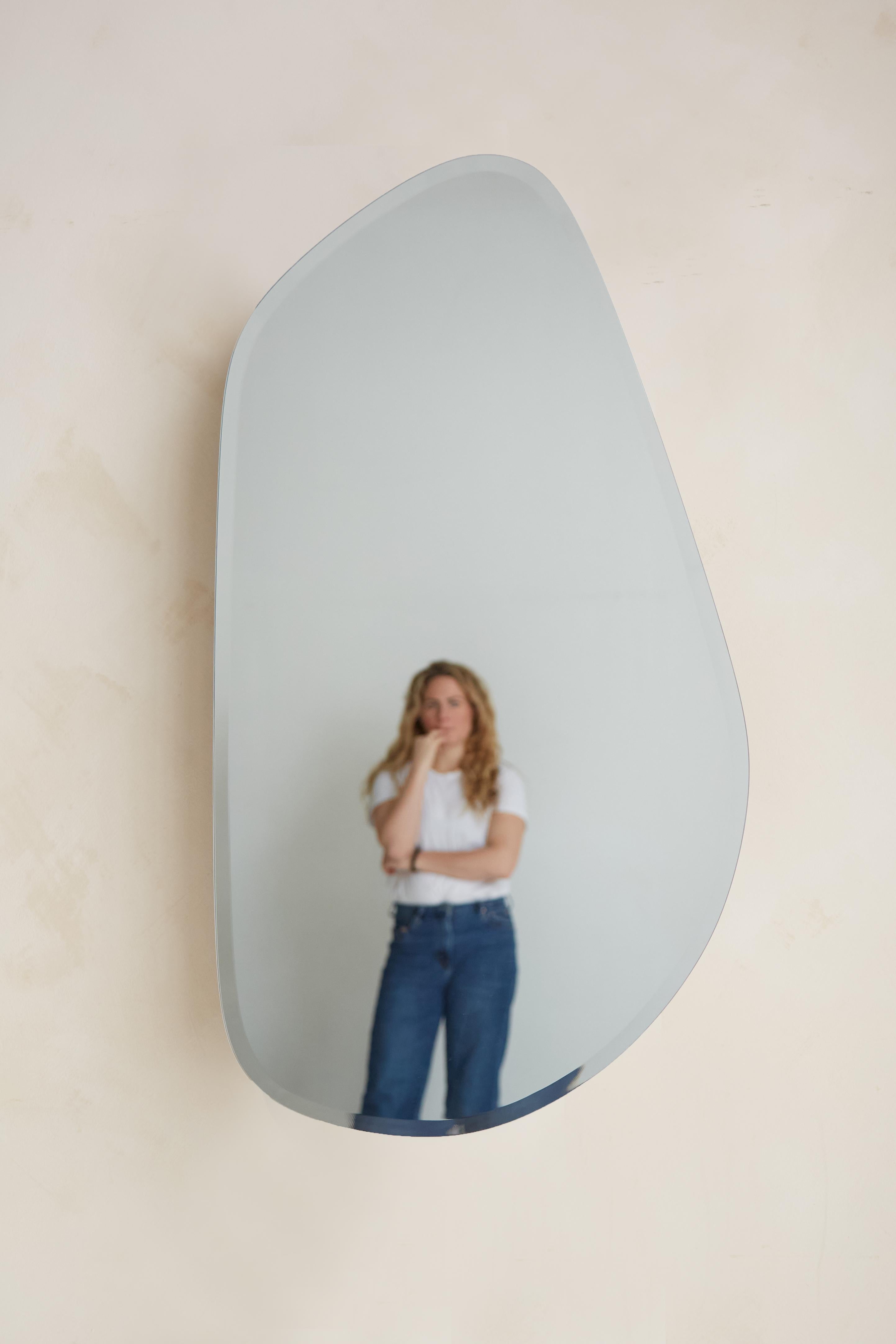 MIROIR GÉOMORPHE
Le miroir Geomorph constitue une rupture visuelle avec le reste de l'ameublement, reprenant la même inspiration en matière de design sans aucun élément en bois visible.  Sa forme organique rappelle les galets de plage doux et