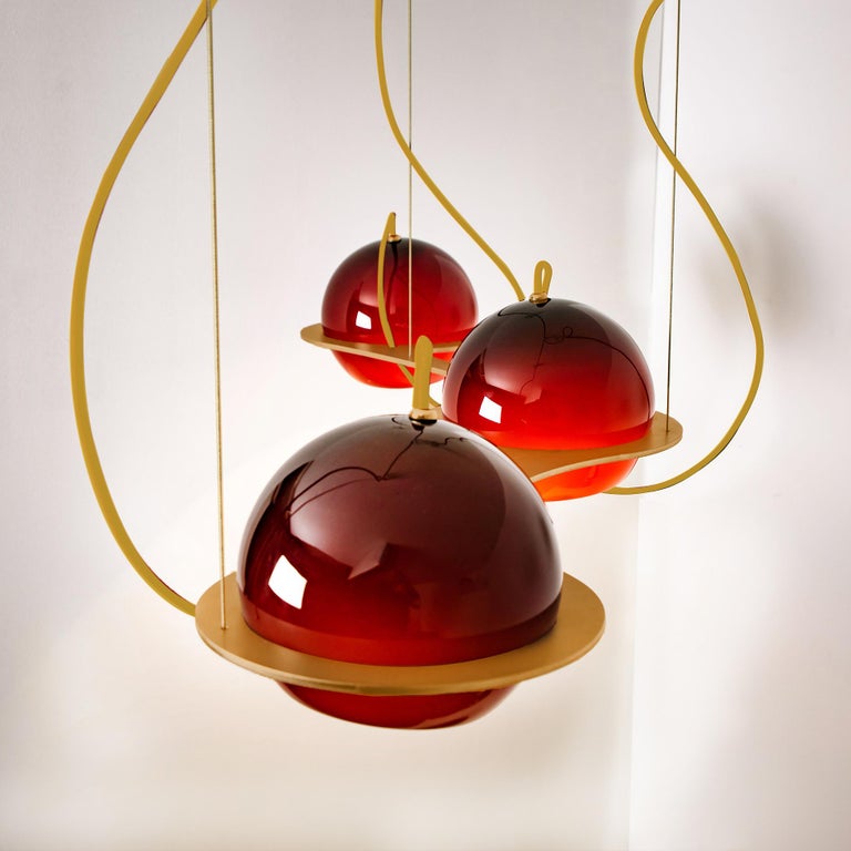 These stunning hand blown light spheres are nestled in a massive brass frame. The spheres can shine in an upwards or downwards direction. Each sphere also features a small hole, ensuring that it remains compact and preventing shadows in your