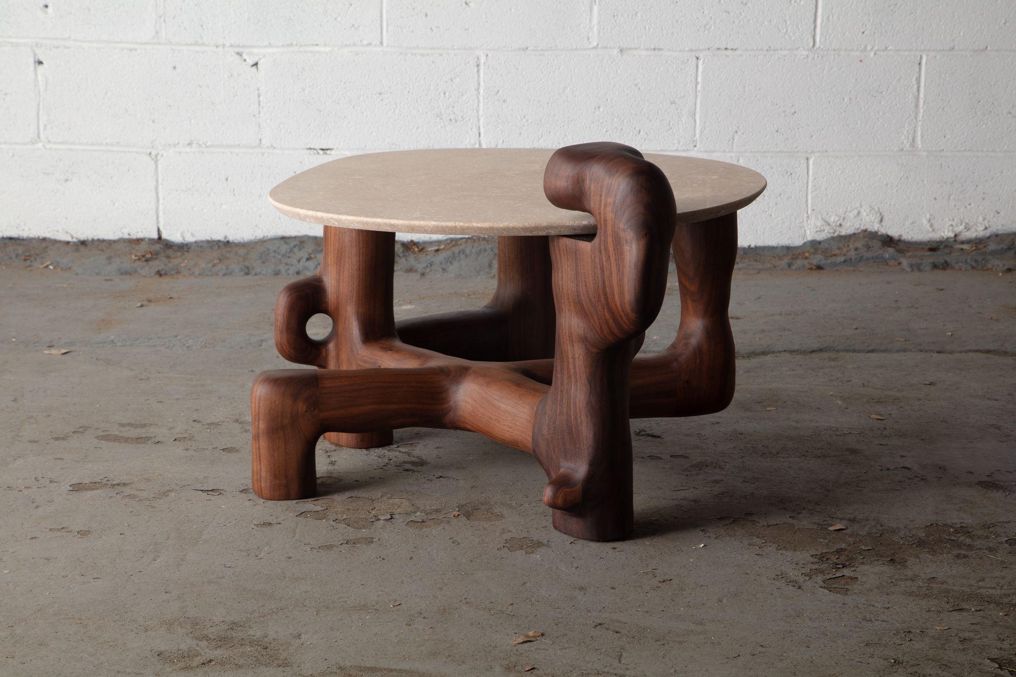 Organic hand carved sculptural side table in oiled walnut. Made in the USA by Casey McCafferty.

Top is travertine stone and can be customized with additional cost.

Pictures shown of this sculptural piece are a depiction what yours could look